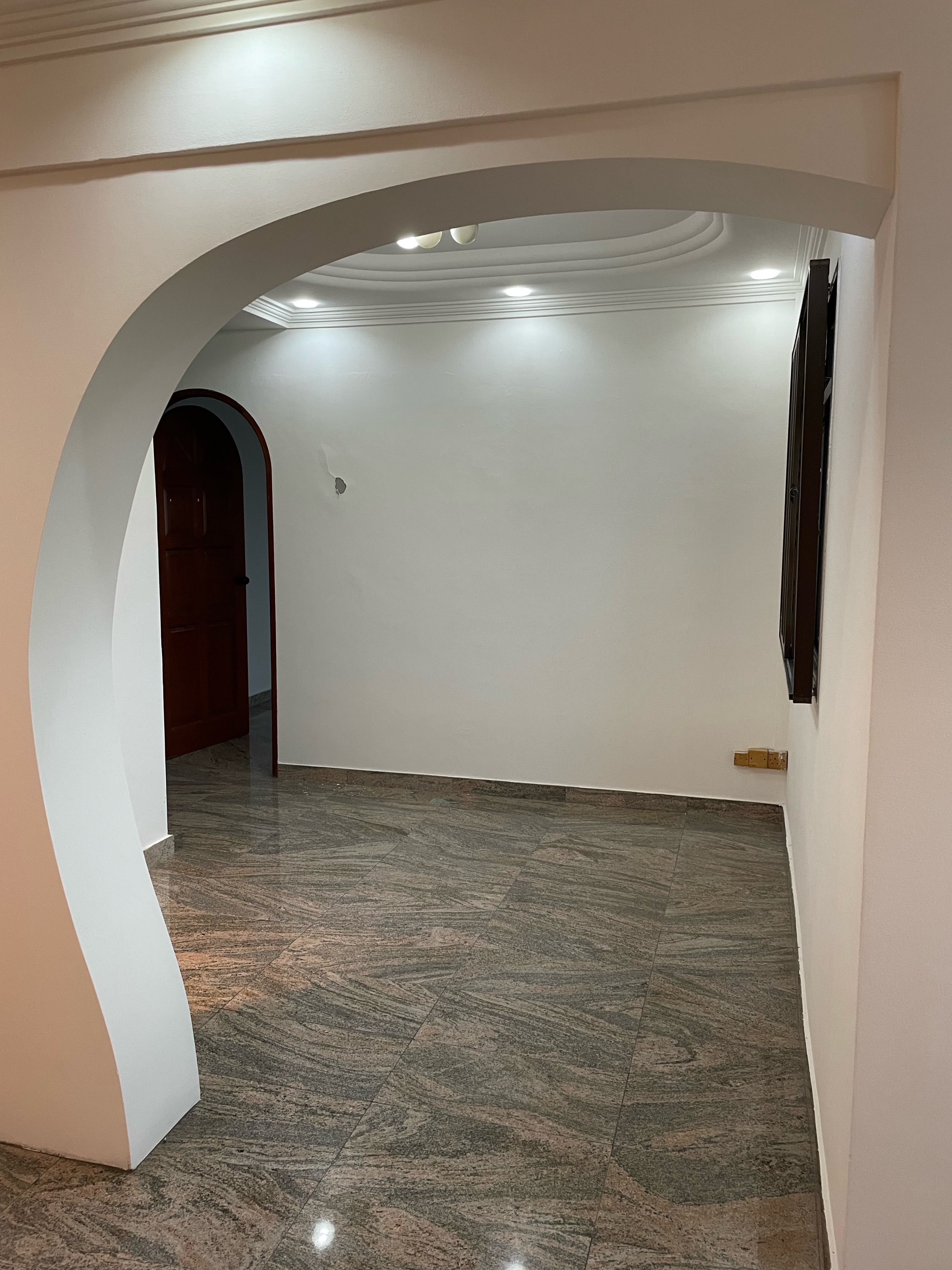 Optimising space: Where aesthetics meets functionality - Arched doorway, white walls, recessed lighting, marble floor, modern