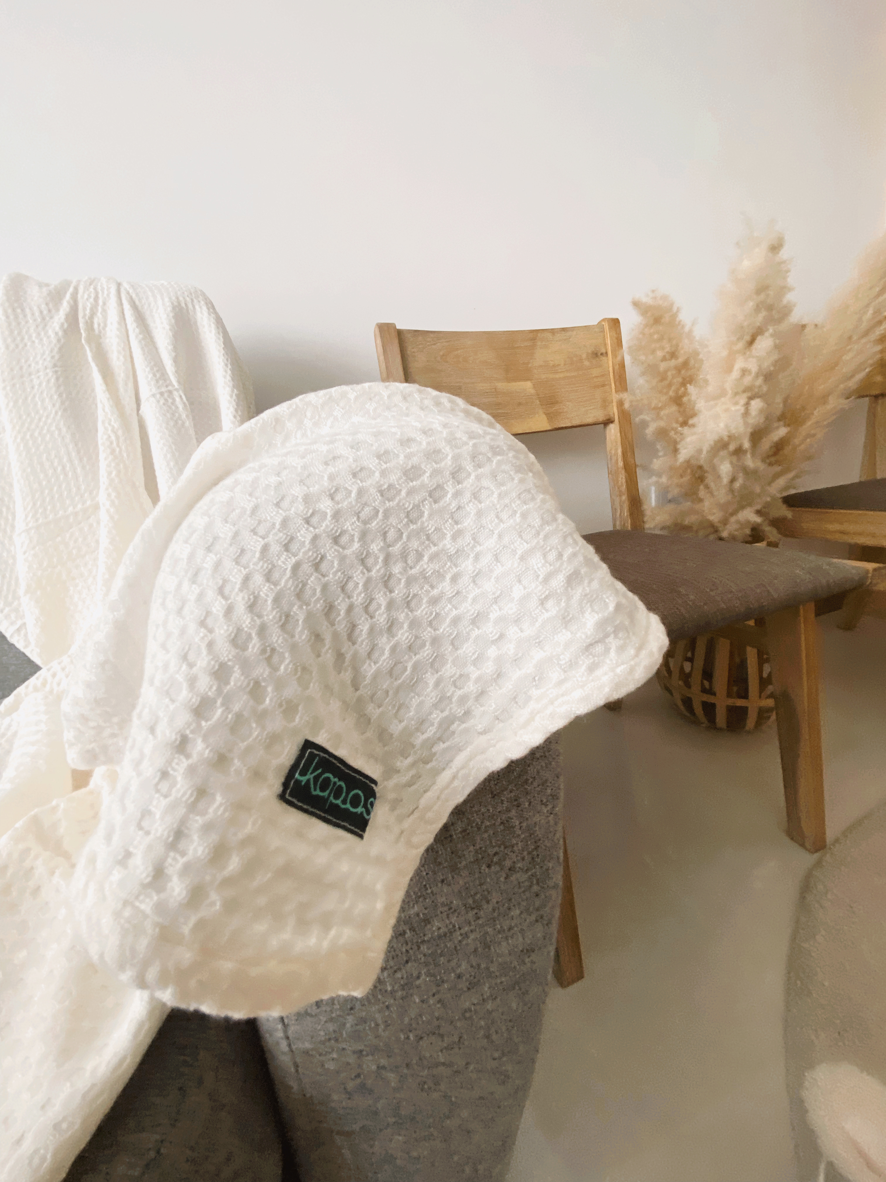 Style + Comfort In This Multi-Functional Living Room - White textured blanket, cozy chair, soft cushions, rustic wooden