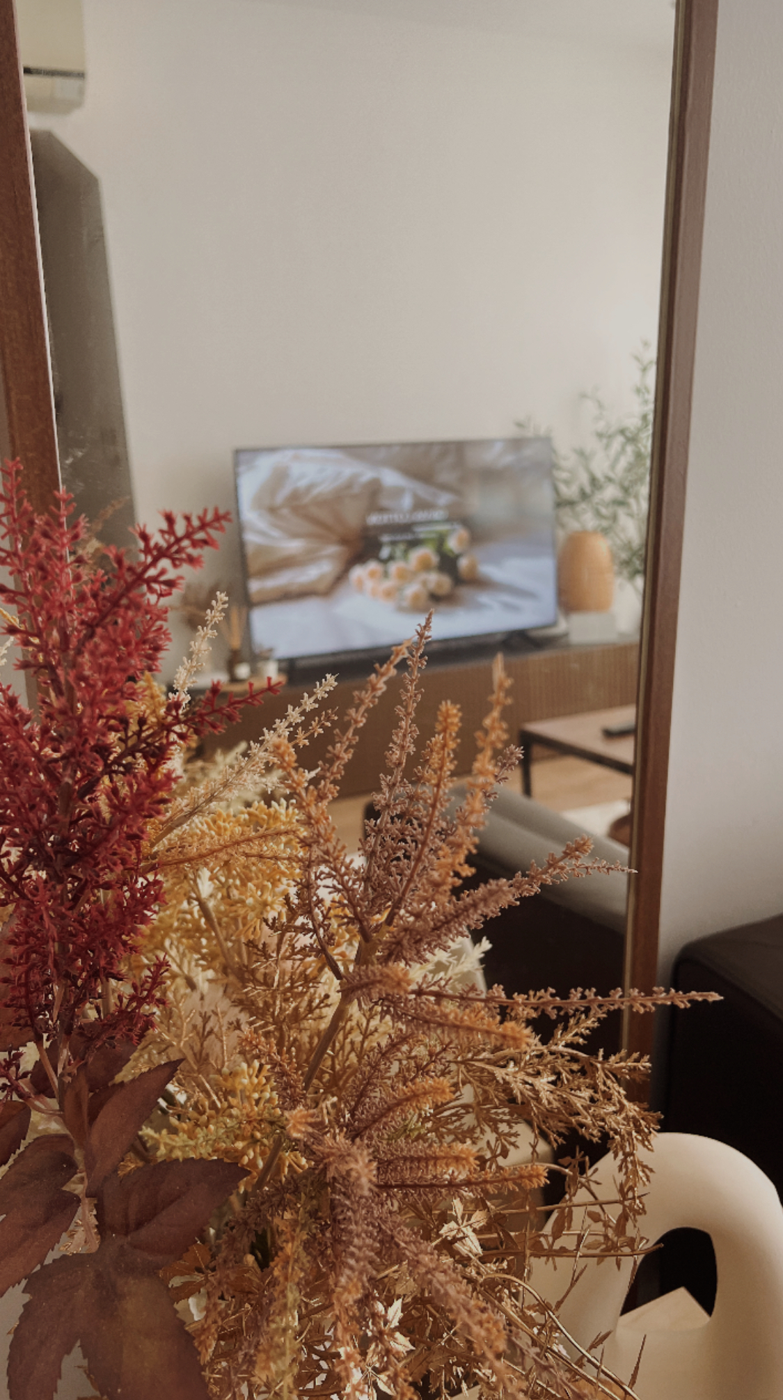 Our warm & comforting Japandi-inspired living room - Warm autumn foliage, soft lighting, indoor setting, cozy atmosphere