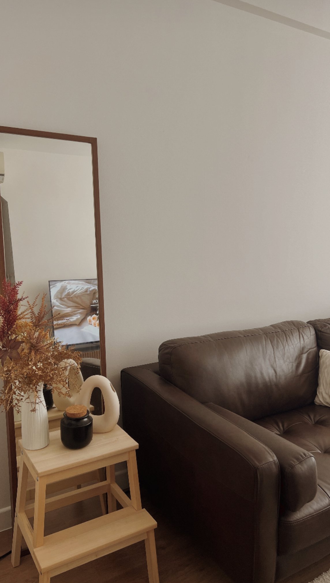Our warm & comforting Japandi-inspired living room - Brown leather sofa, minimalist decor, wooden side table, autumn-themed