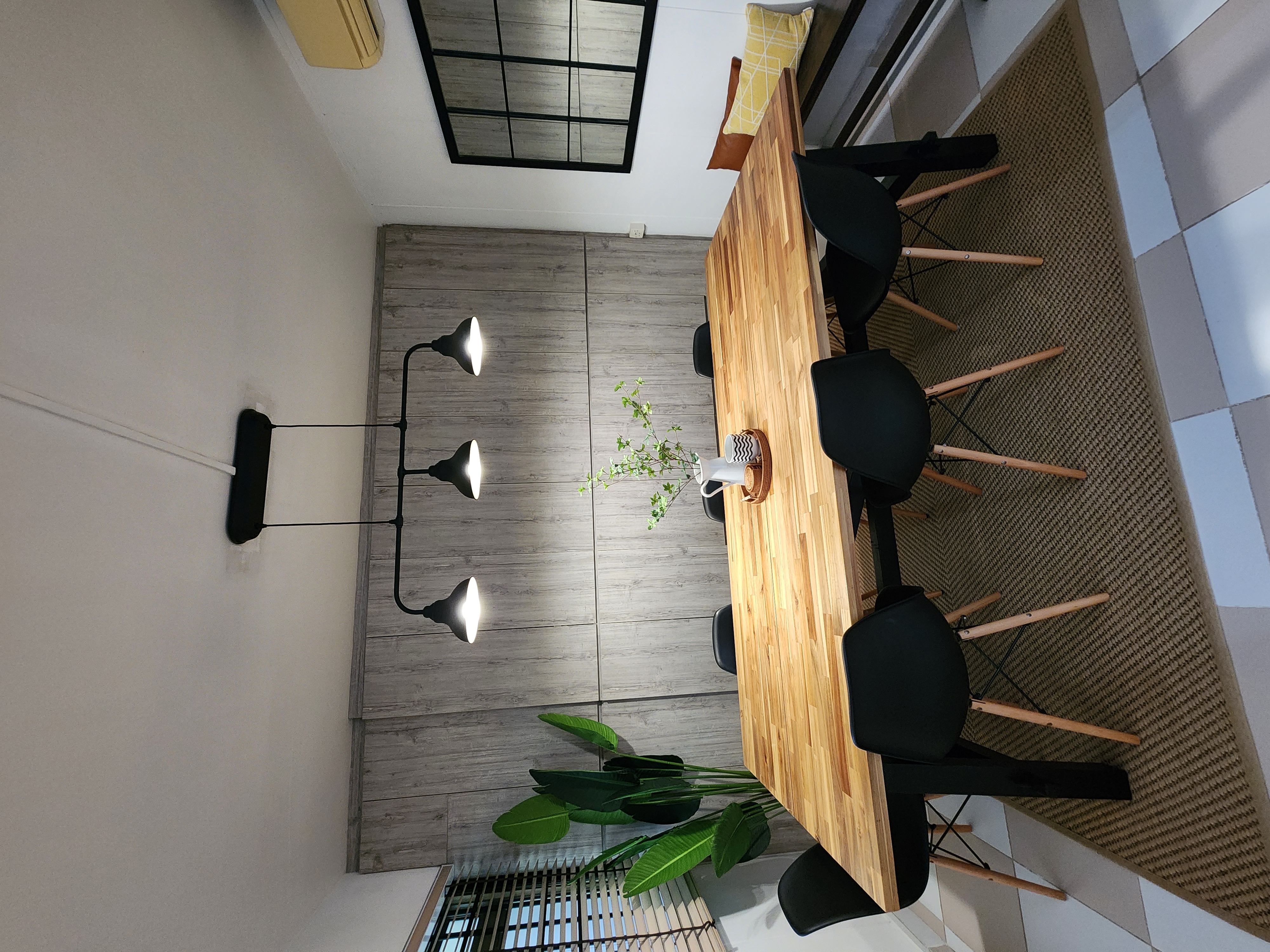 Multi-Functional Dining Room - Wooden dining table, black chairs, modern decor, minimalist design, natural light, indoor
