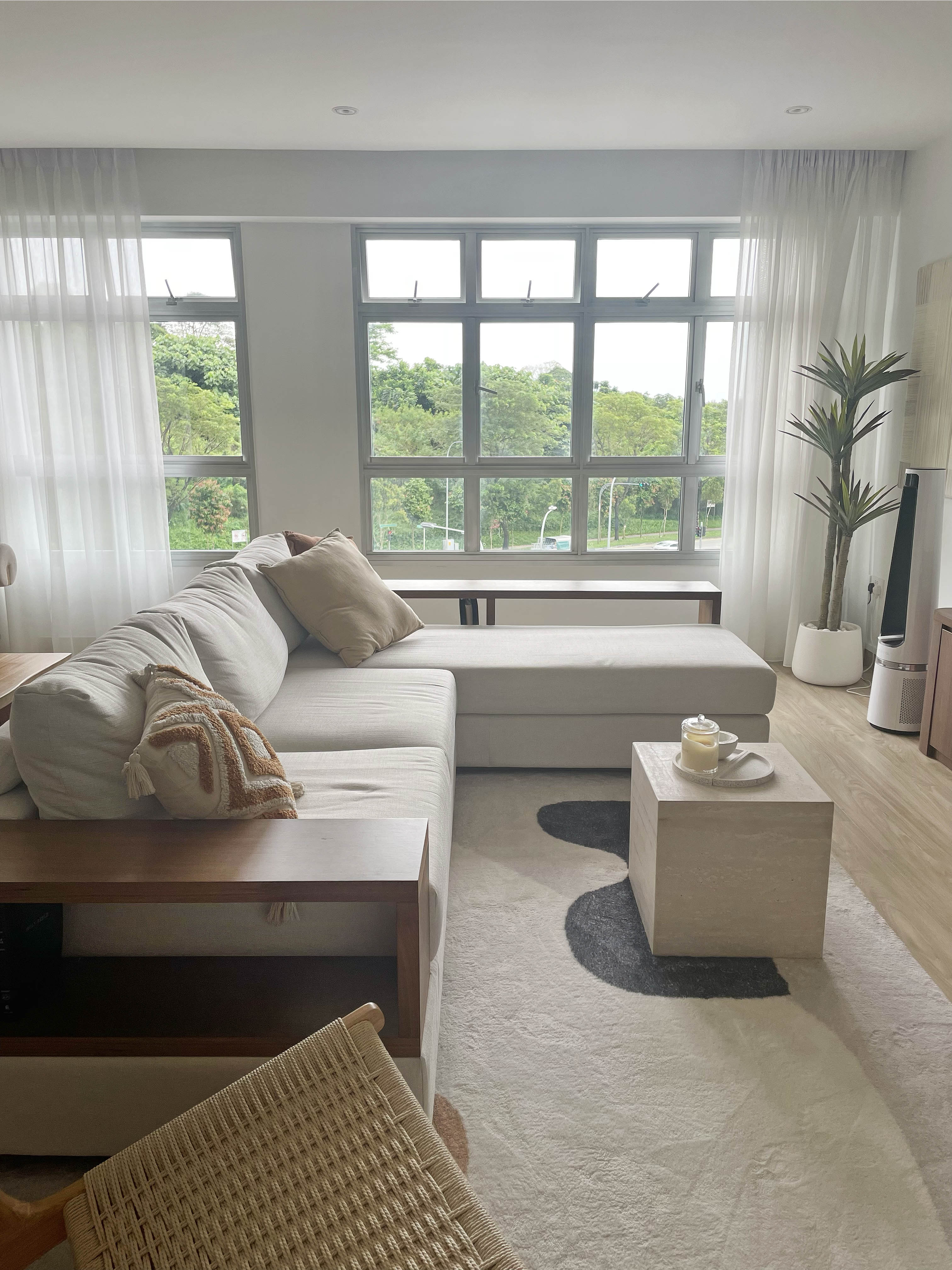Creating A Cozy Living Room - Modern living room with large windows, light beige sectional sofa, plush throw blanket, wooden