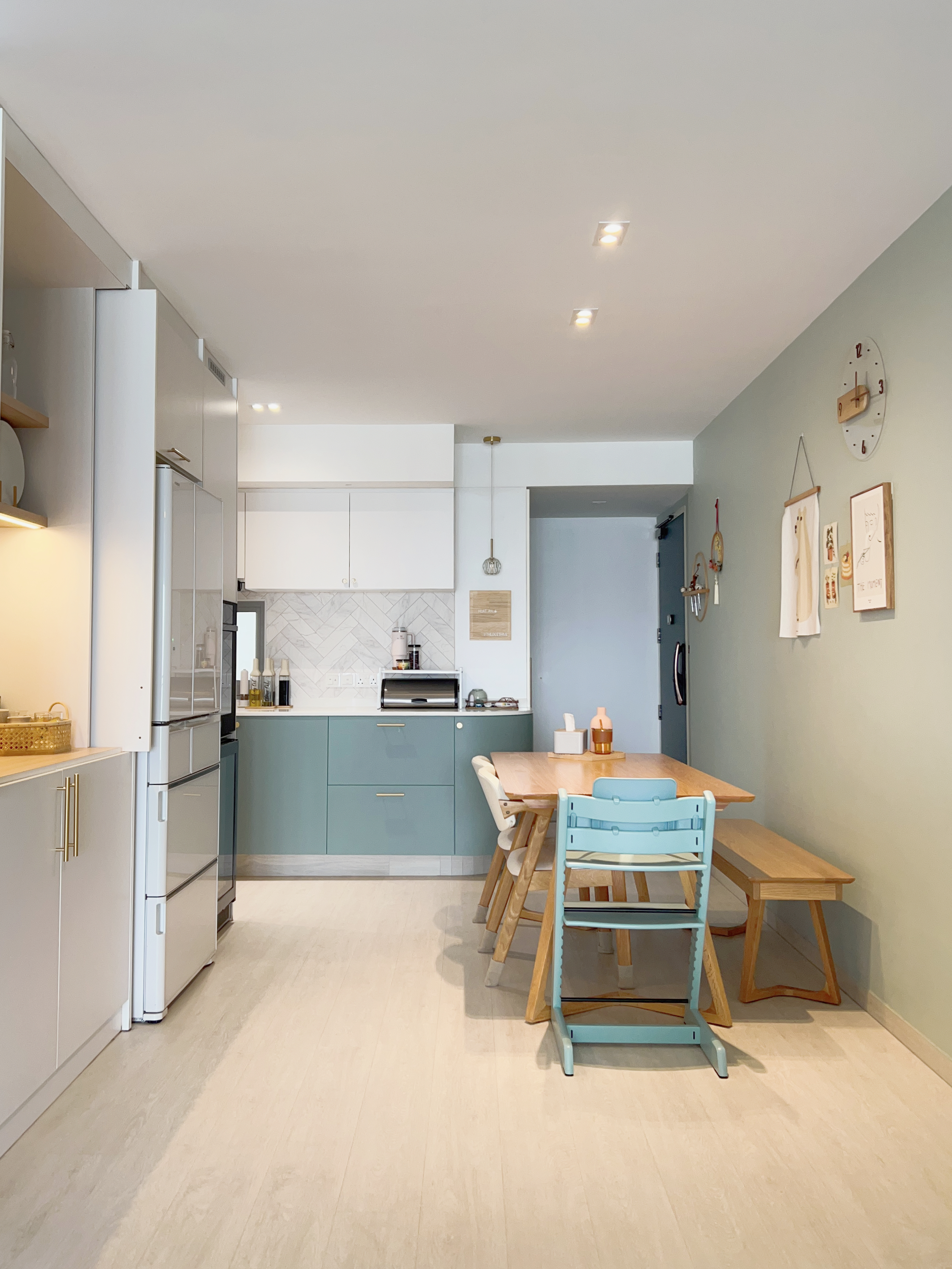 A Kids Friendly Kitchen + Dining Integrated Space  - Modern kitchen with white cabinets, light blue countertops, and a wooden