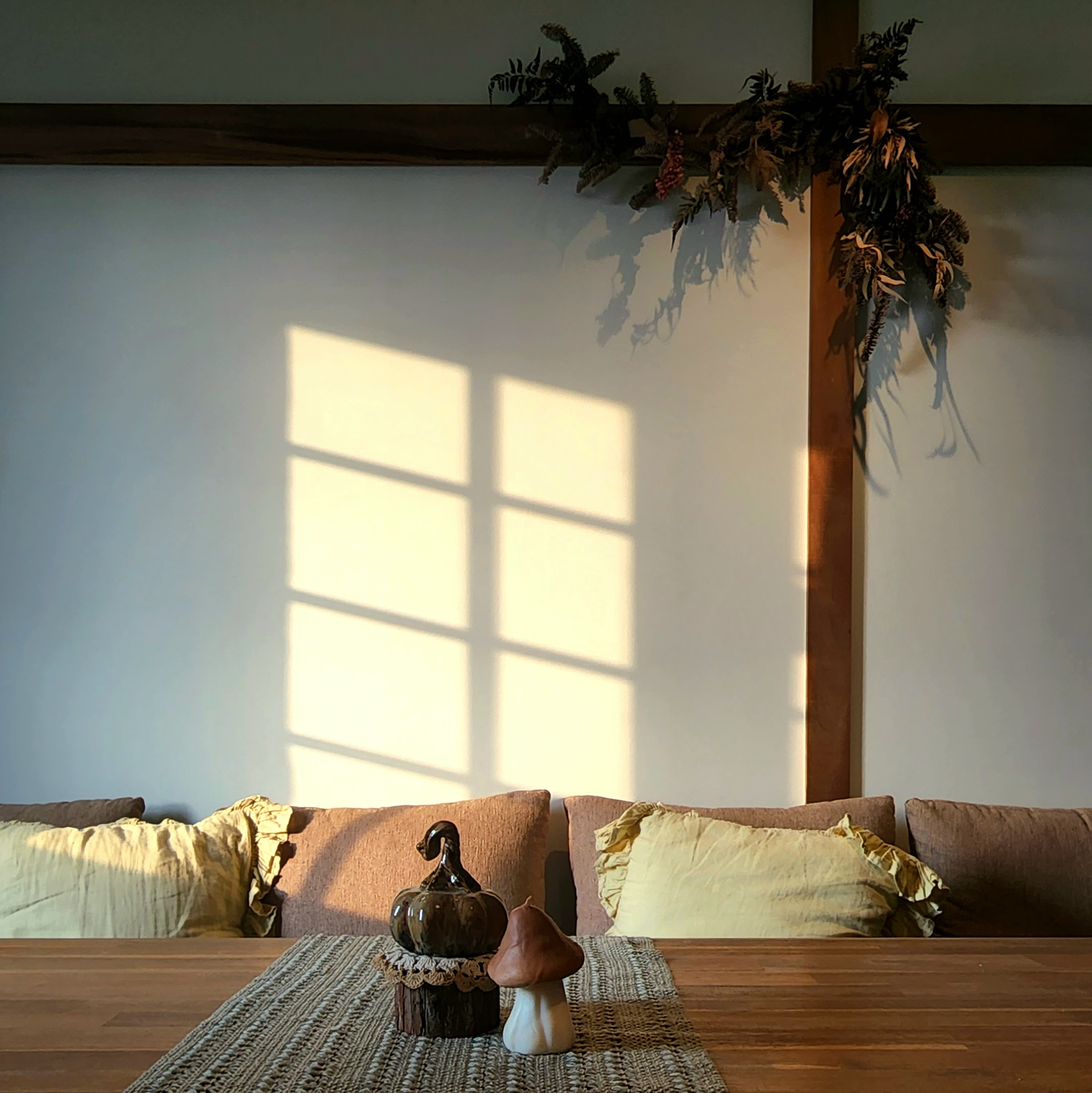 Gather here: Living and dining in the same space - Sunlight streaming through window casts shadows on wall, cozy living room