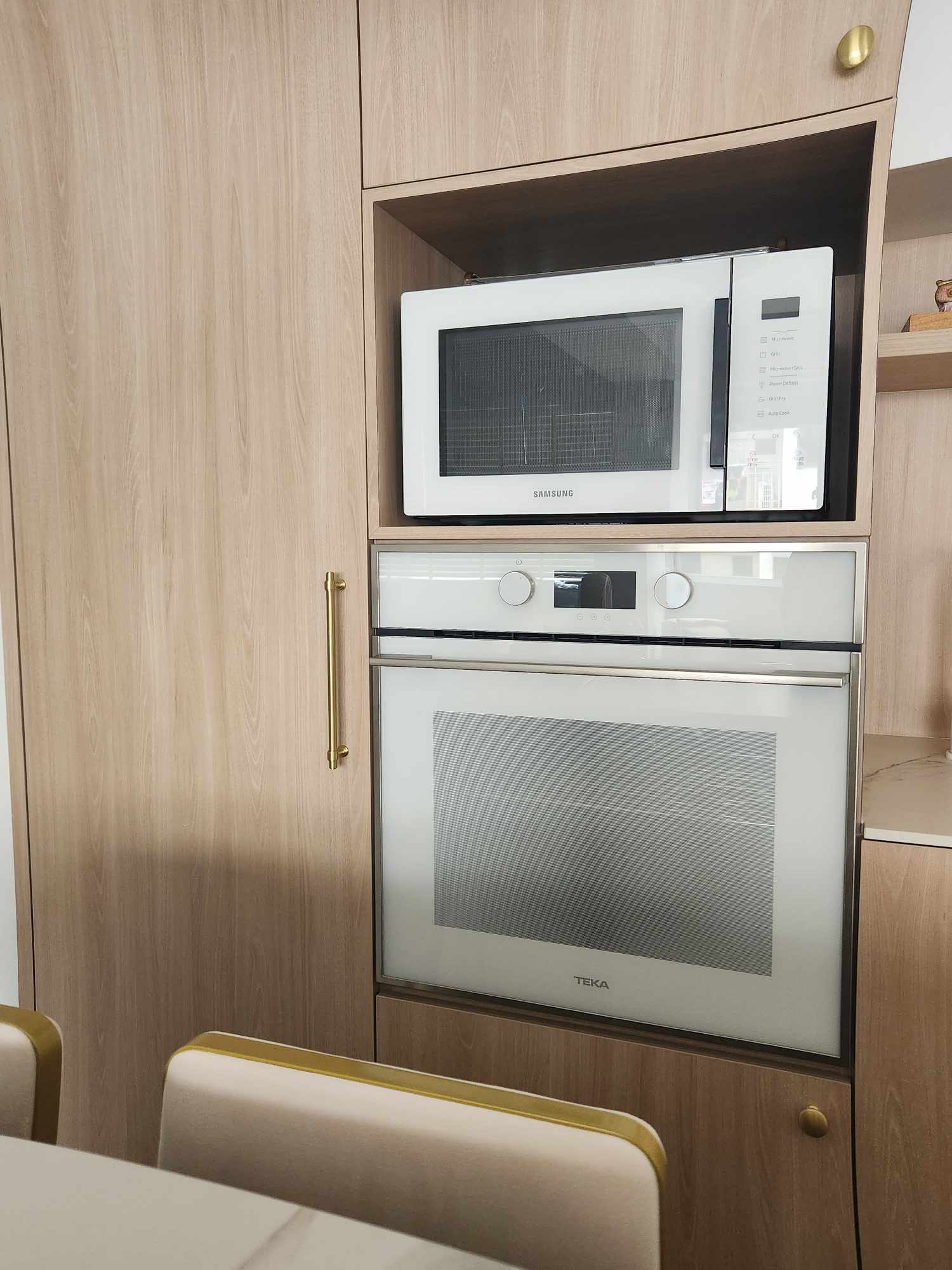 Our cozy dining space with a dry kitchen  - Wooden kitchen cabinets, Samsung microwave, white oven, TEKA brand, modern