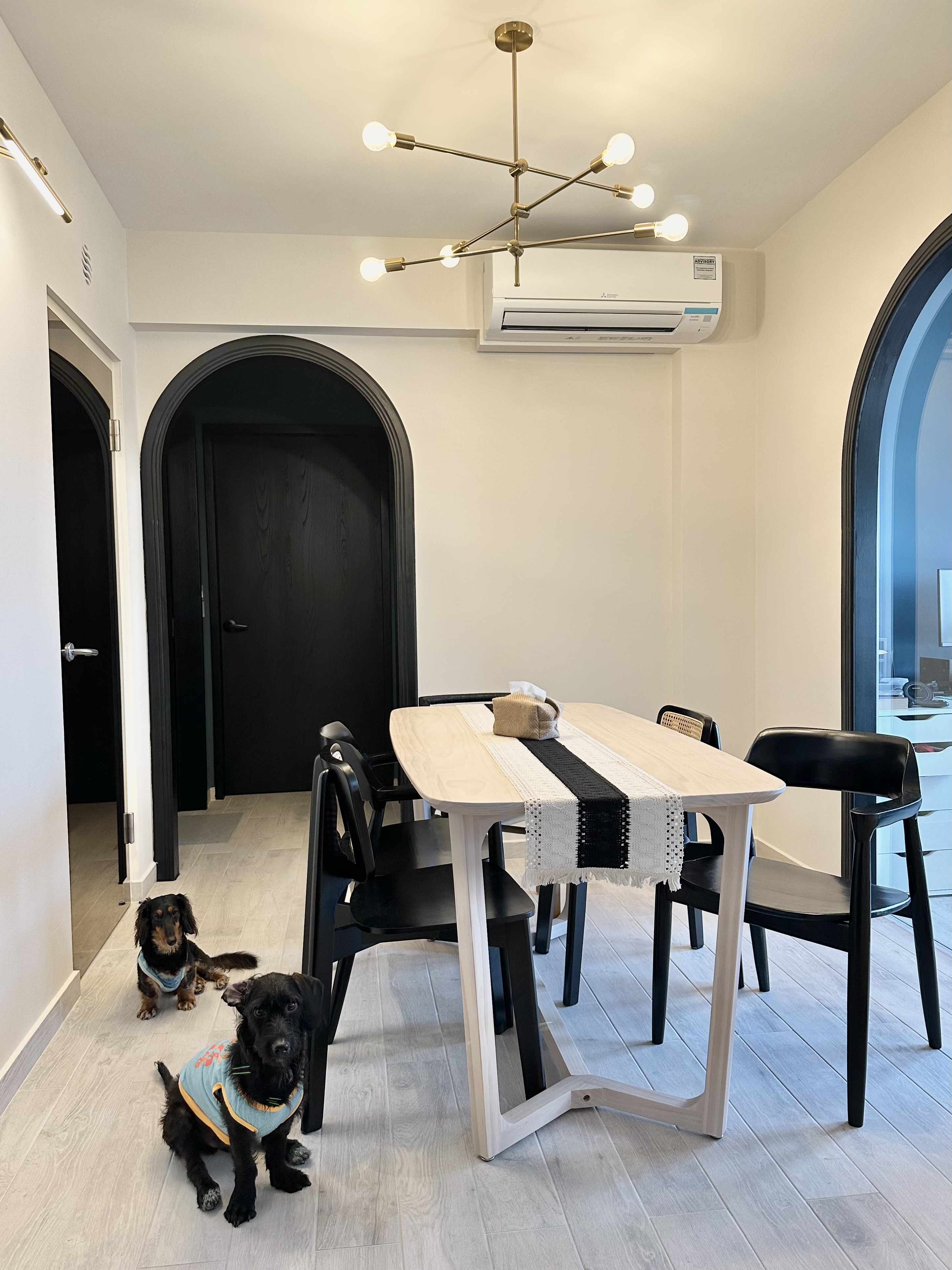 Making space for our dining area!  - Modern dining room with sleek black chairs and a wooden table, contemporary light