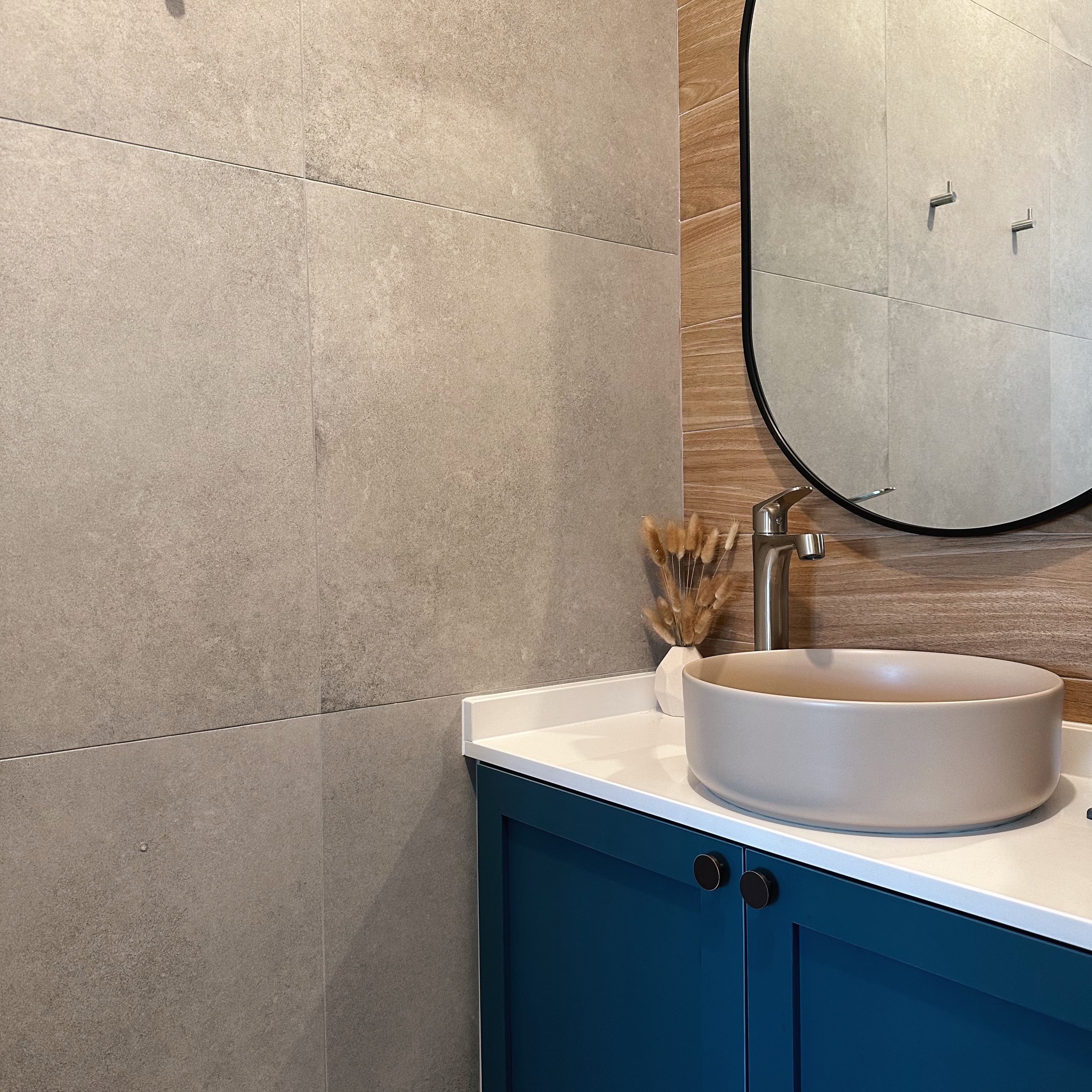 Really just warming up  - Modern bathroom vanity, beige tiled wall, sleek sink, round mirror, minimalist design, blue