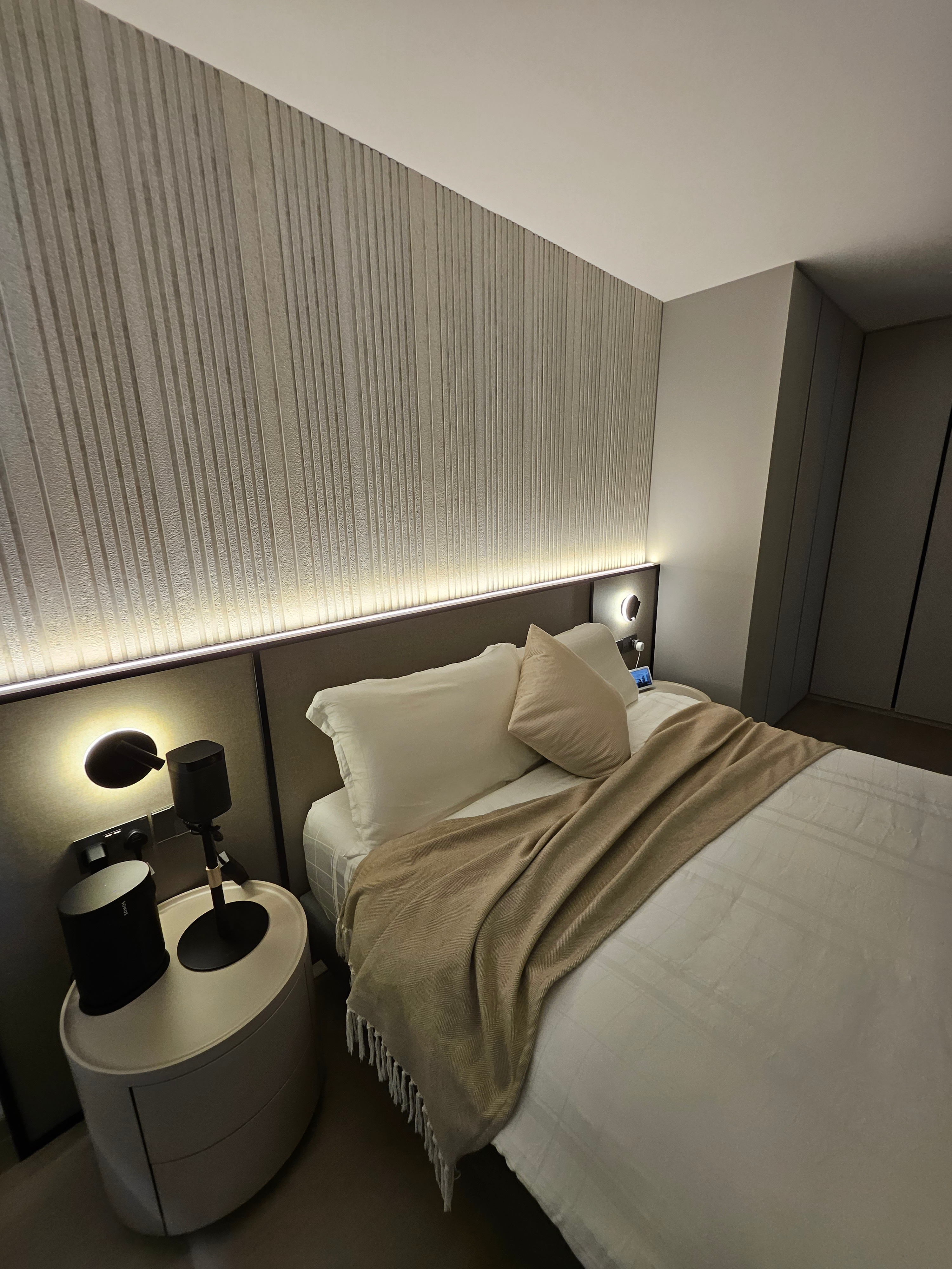 Explore Our Muted and Calming Bedroom - Modern bedroom with sleek design, beige and white bedding, bedside tables with lamps