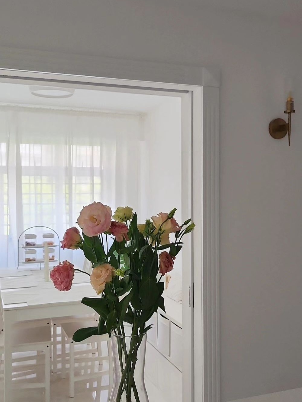 Our private dining room - vivid floral arrangement, pastel pink and yellow blooms, elegant white dining table, minimalist