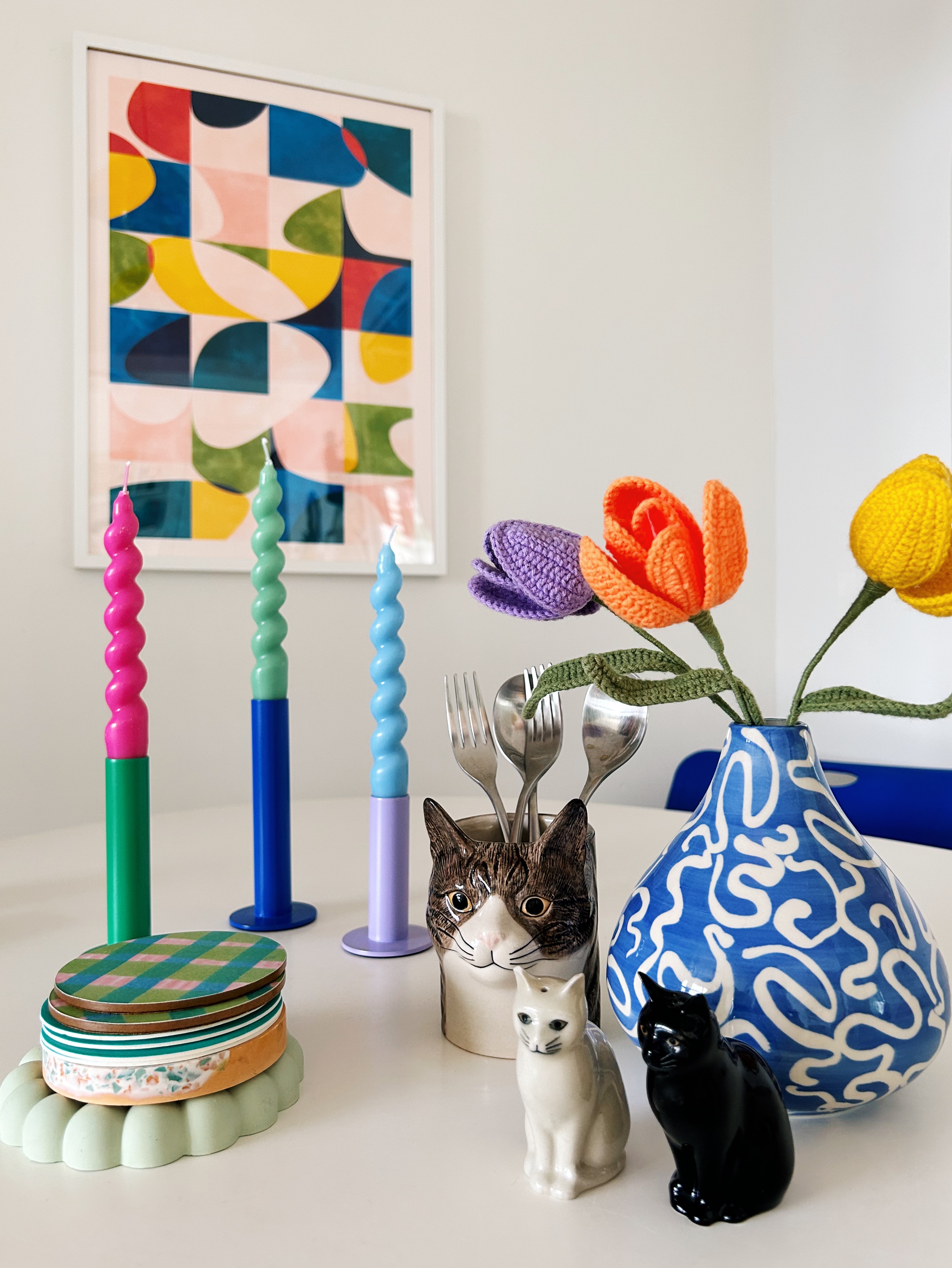Our quirky, multifunctional dining nook  - Candlesticks in pastel colors, colorful abstract painting, knitted tulips, ceramic