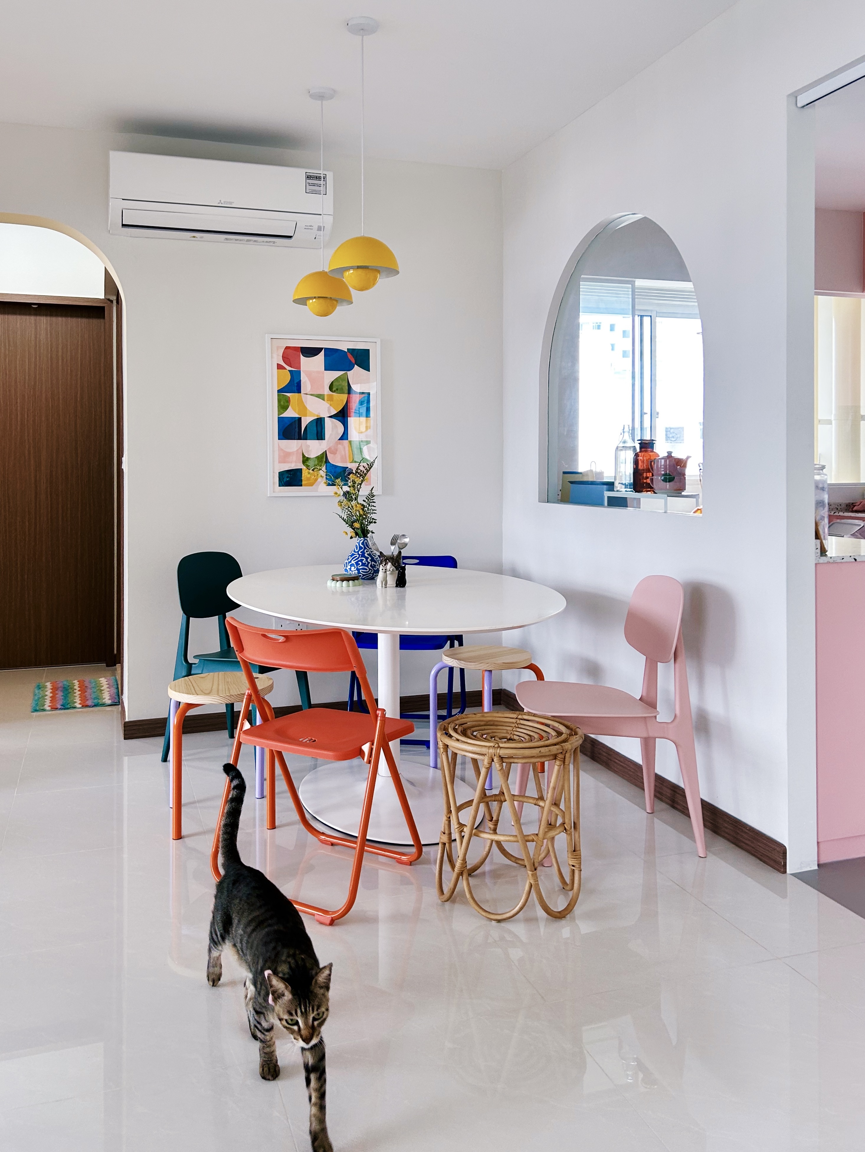 Our quirky, multifunctional dining nook  - Modern dining room with colorful chairs, white round table, abstract artwork