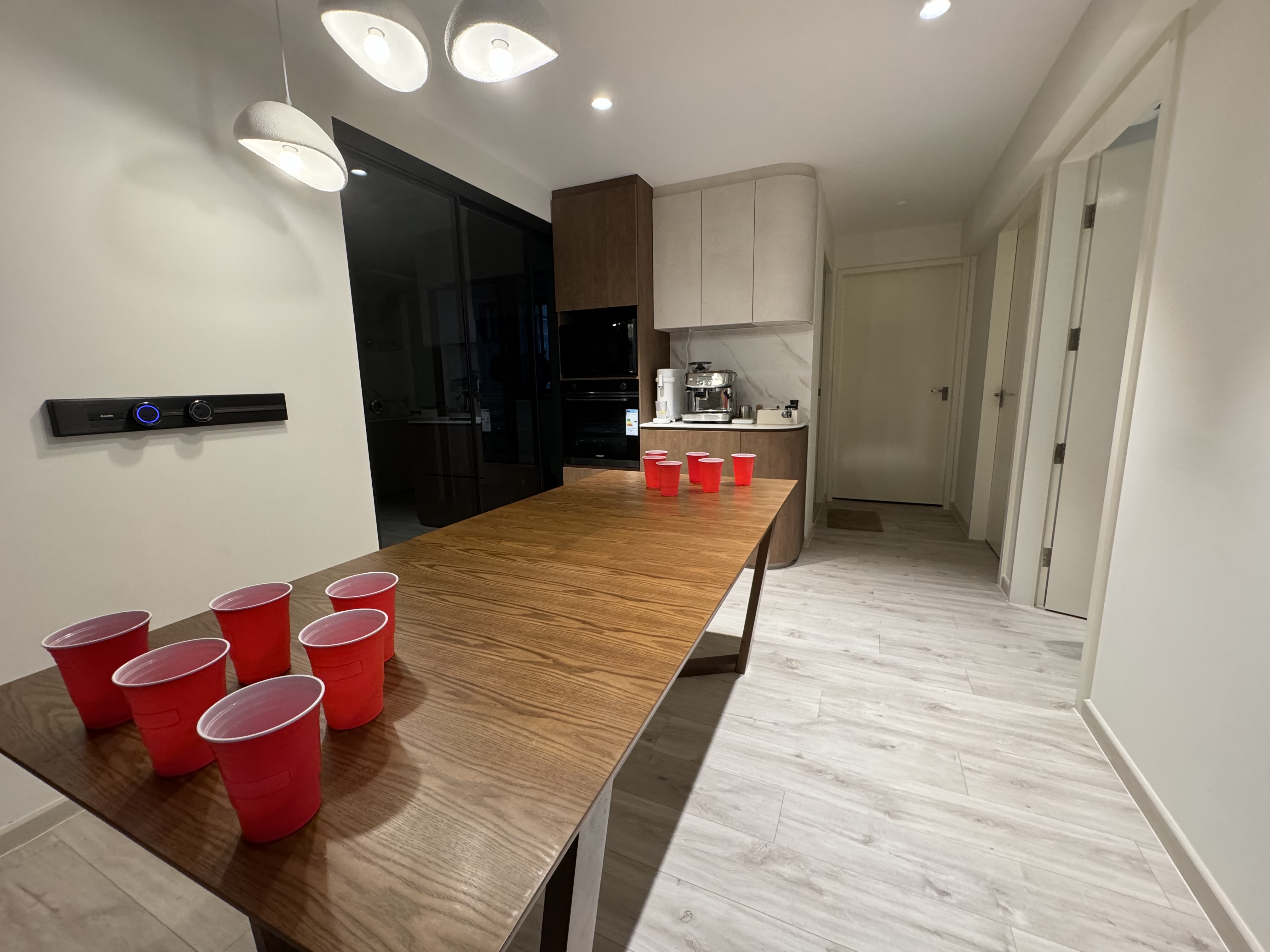 Our versatile dining area - perfect for meals, work, beer pong & more! - Modern kitchen with wooden dining table, red plastic