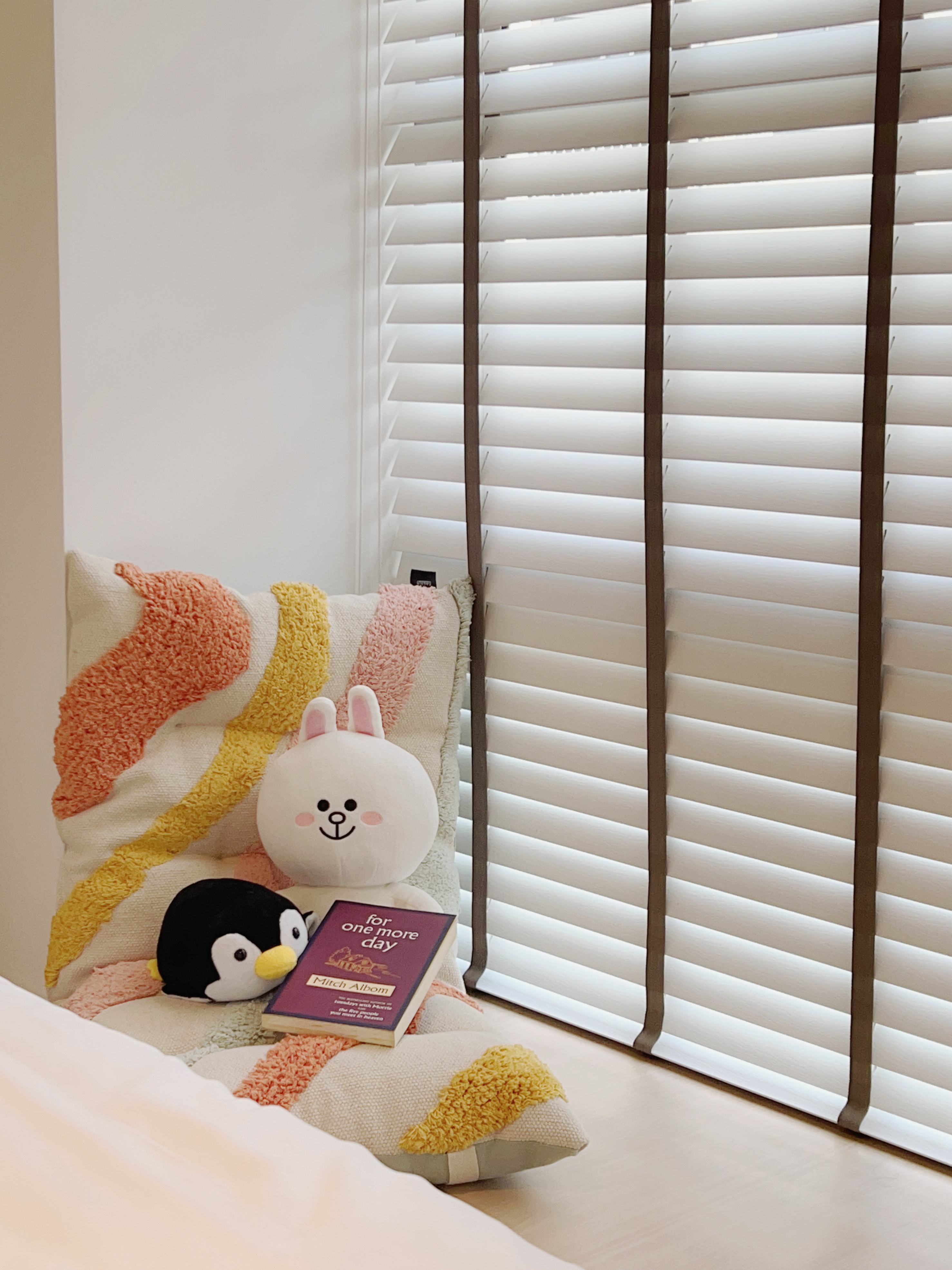 Maximising Bay Windows to Create A Cozy & Functional Master Bedroom - Soft, colorful throw blanket, plush bunny, penguin toy