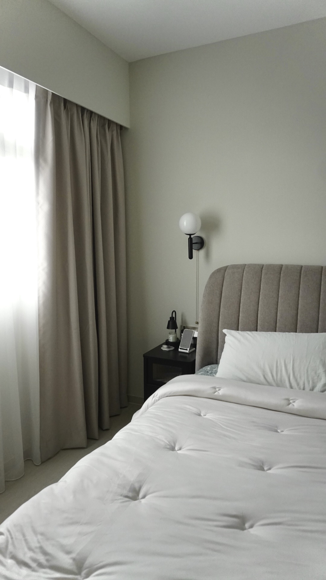 Our bedroom; the room behind the reeded glass doors - Light-colored, modern bedroom with plush, white bedding and a tufted