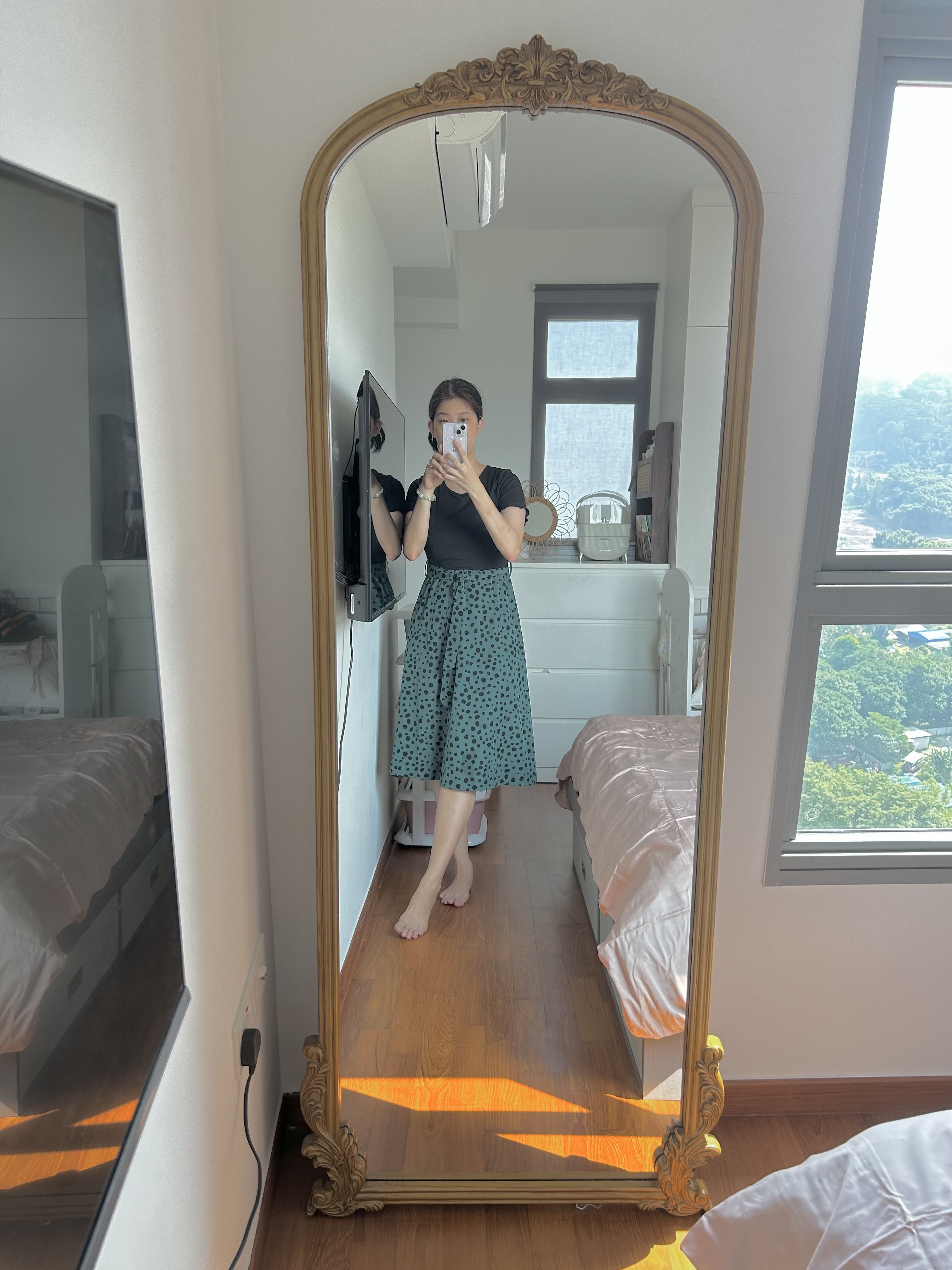 Master Bedroom: Our Tranquil Oasis - Golden ornate mirror, person taking selfie, black top, green polka dot skirt, white bed