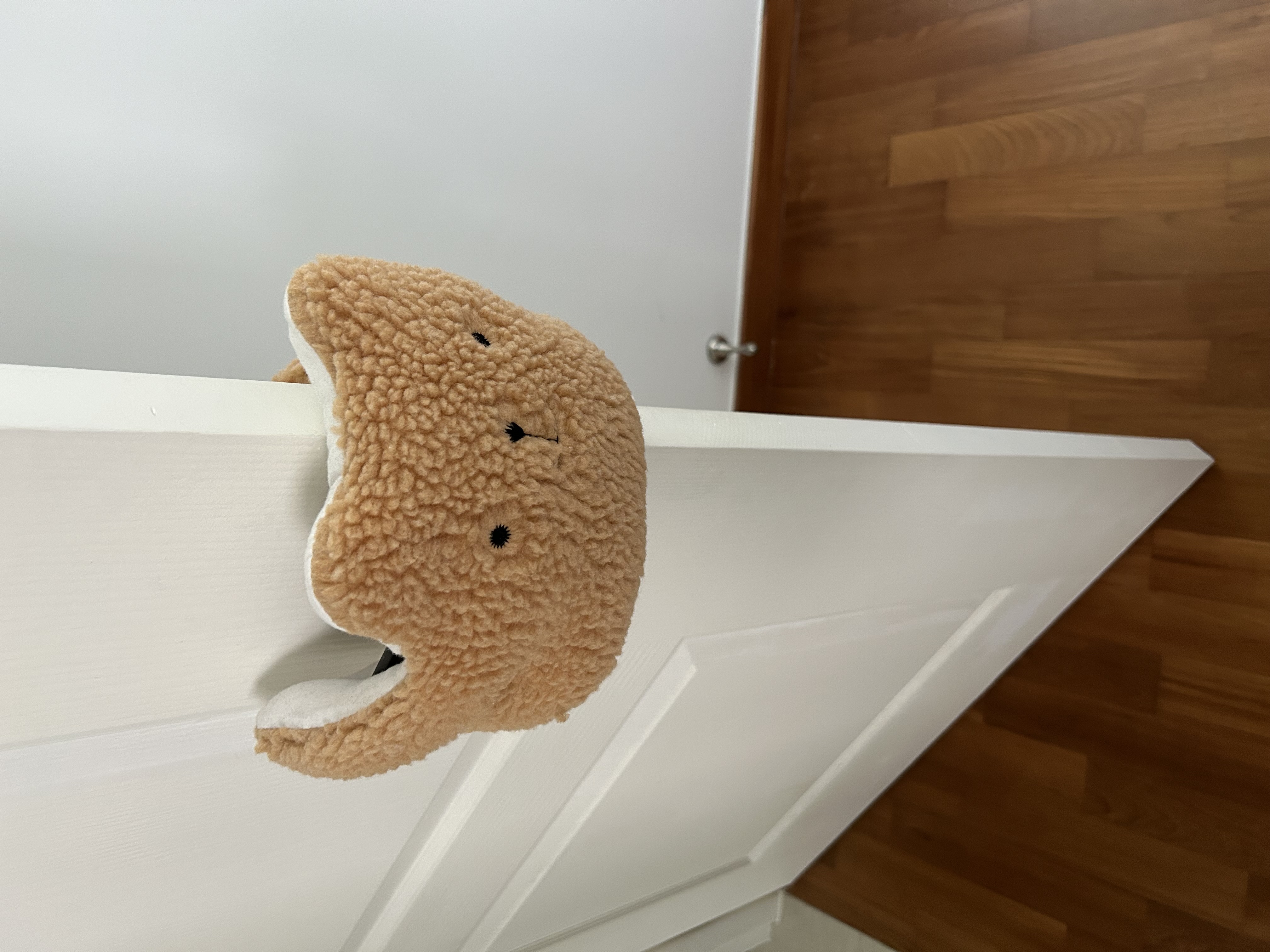 Master Bedroom: Our Tranquil Oasis - Soft, beige plush toy with black eyes and mouth, peeking out from a white door frame