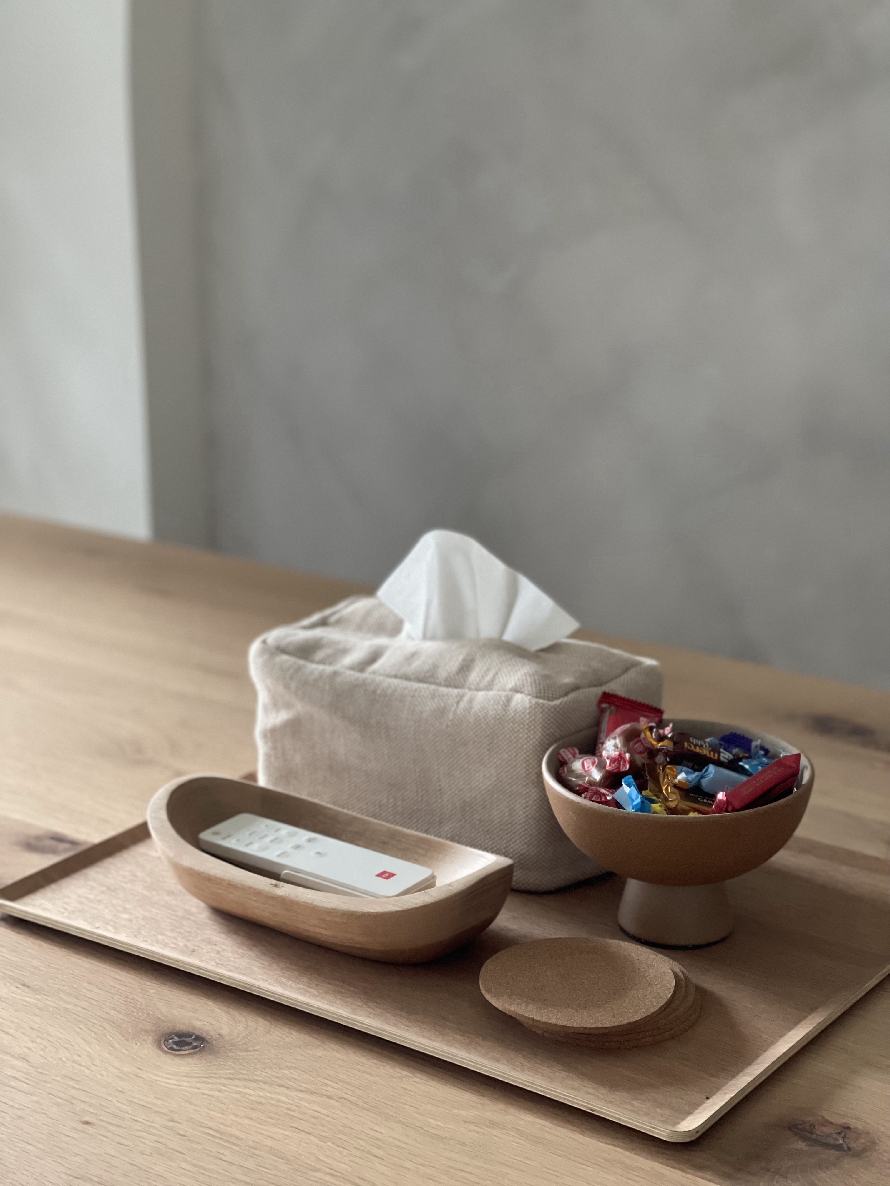 The Dining Area: The Heart of Our Home  - Wooden tray, beige fabric pouch, white tissue box, wooden coaster, remote control