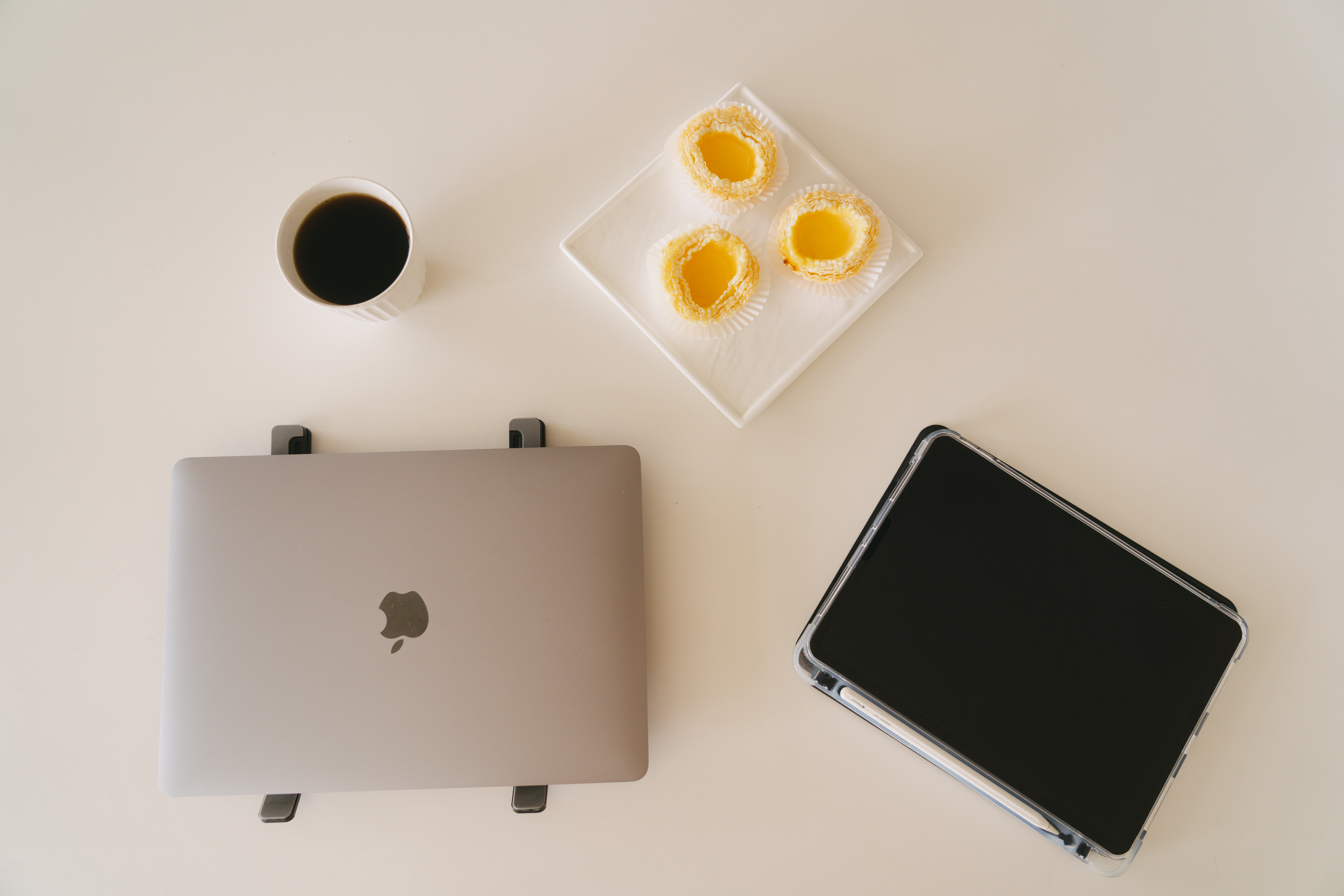 A place where food and conversations meet – Dining area - Coffee cup, laptop, tablet, white surface, minimalist design