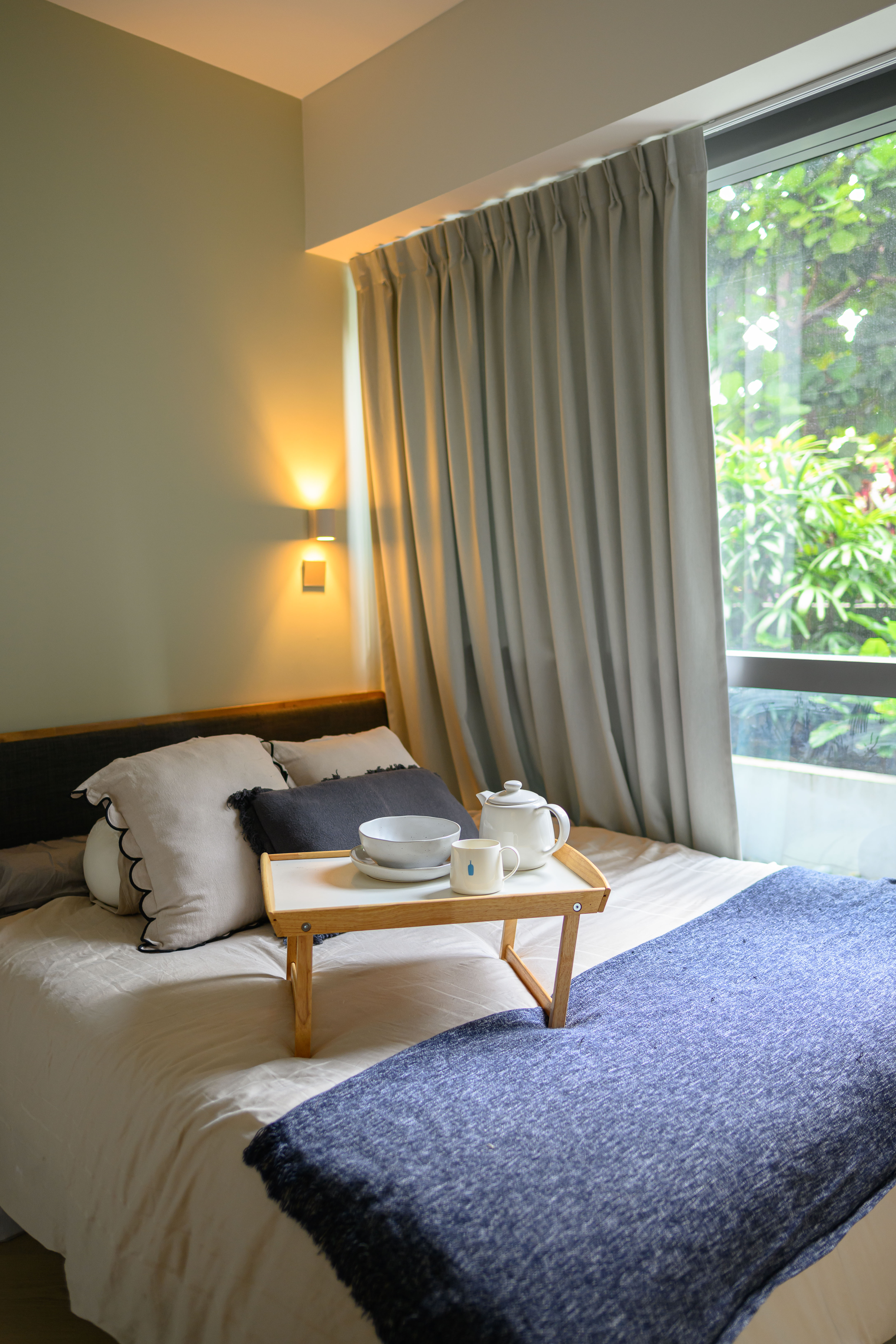 Restful and Snug space  - Modern bedroom with cozy ambiance, soft lighting, neutral color palette, large window with green