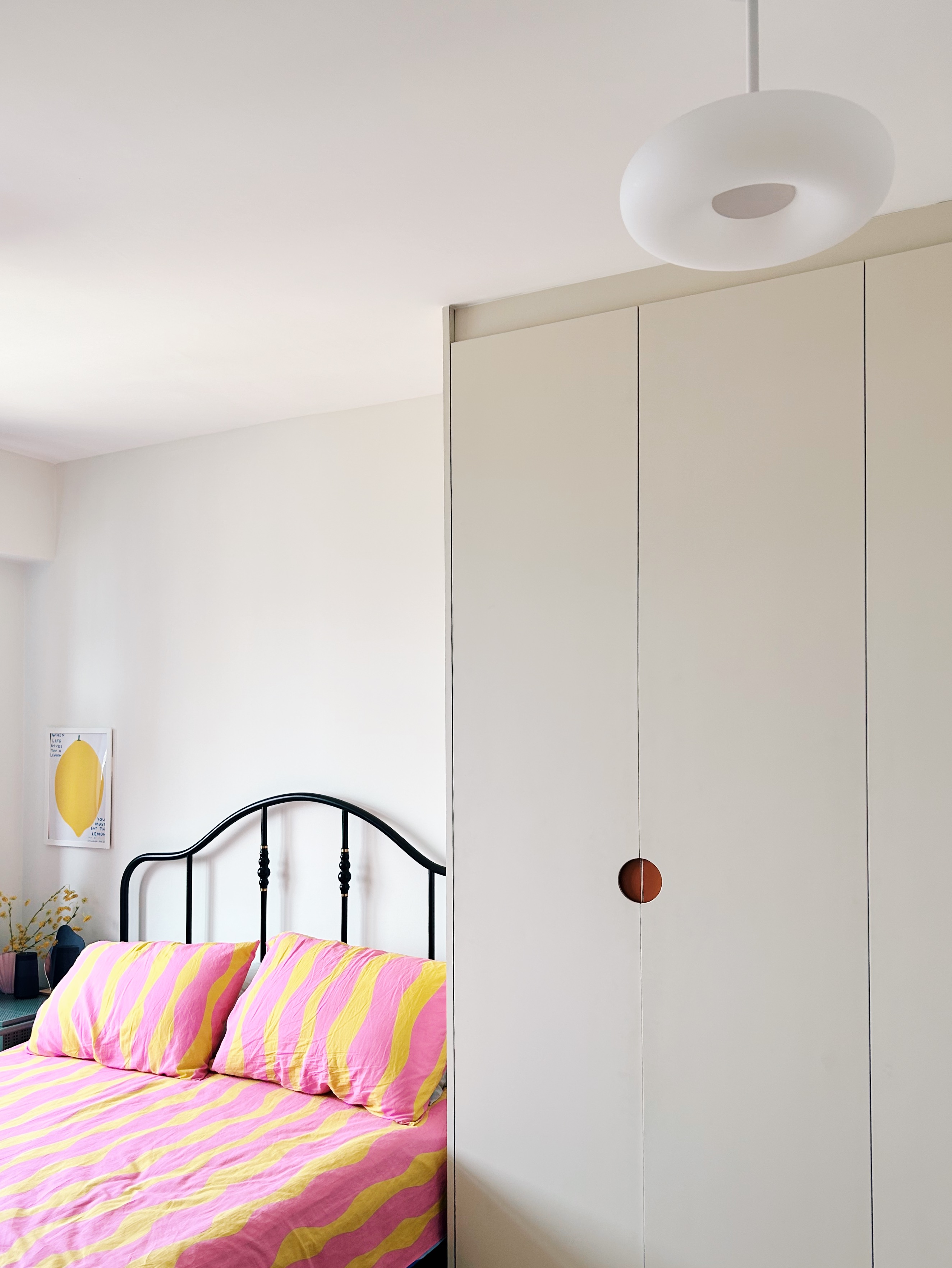 Step into our simple, sleep space - Brightly colored striped bedding, modern white wardrobe, minimalist decor, yellow lemon
