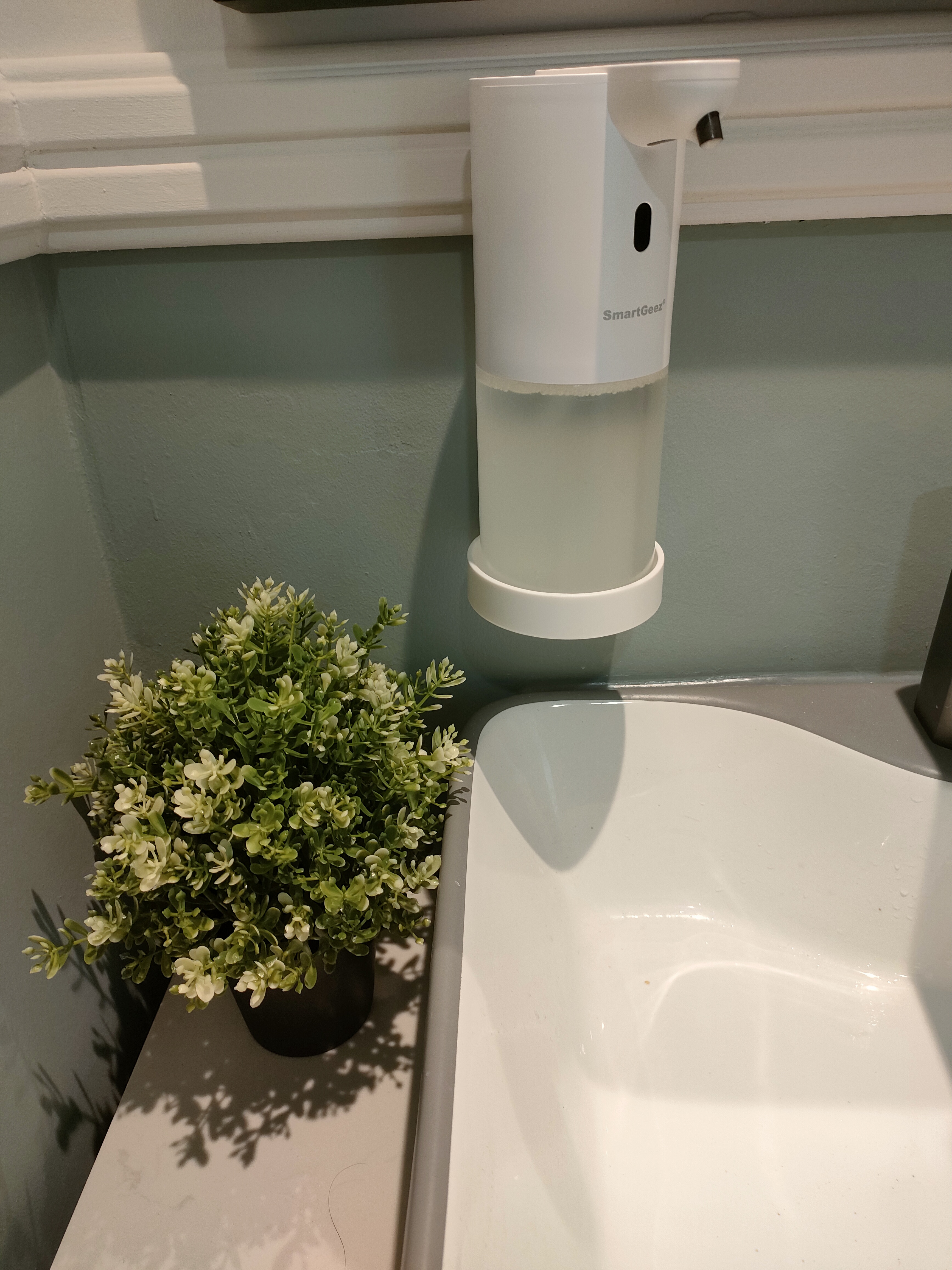 No Gardenspace for us! - SmartGez water dispenser, white cylindrical dispenser, green plants, bathroom vanity, white sink