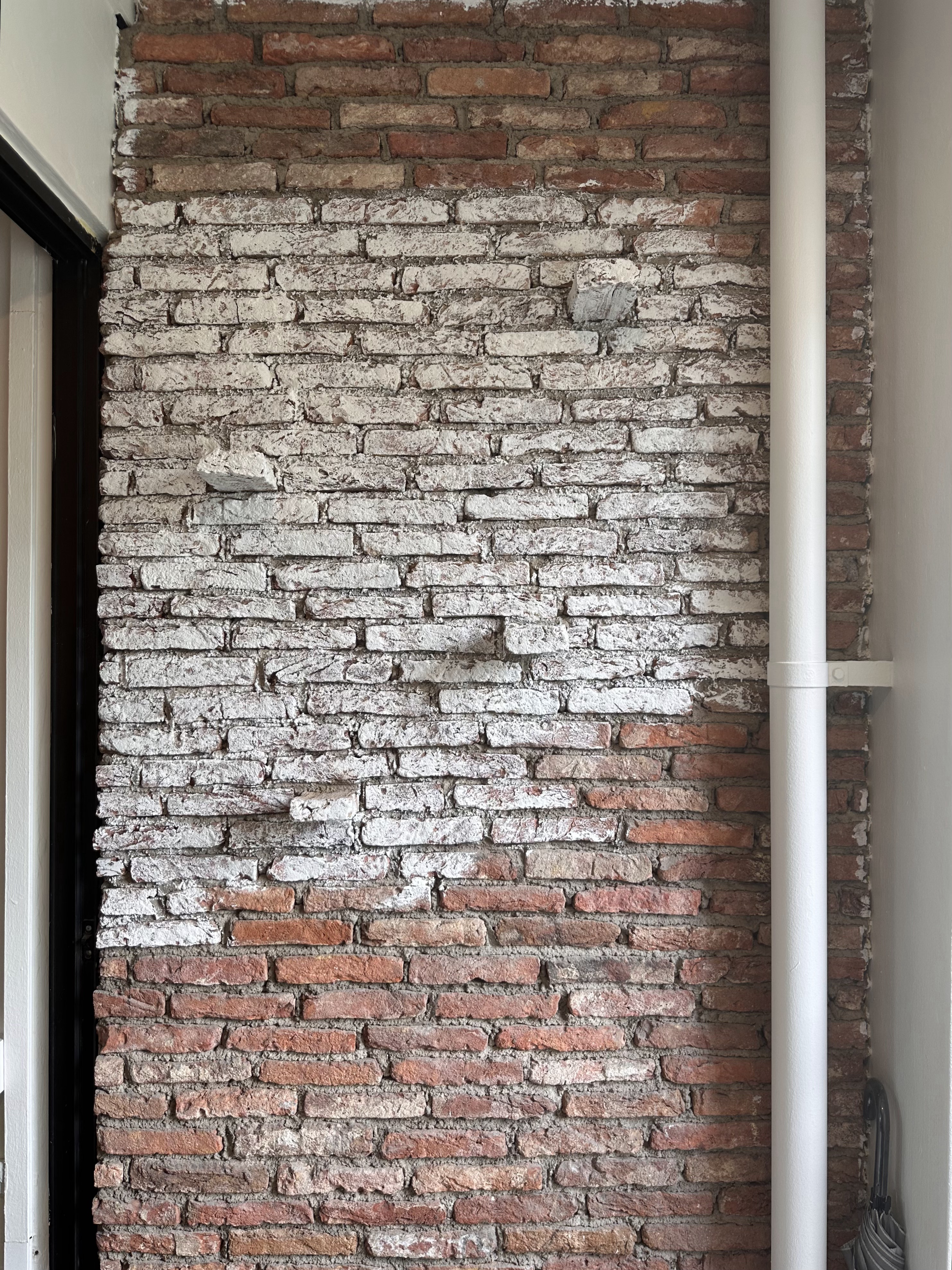 Verde Nook & Vertical Garden - Rustic brick wall, weathered texture, vertical red and white bricks, exposed mortar, natural