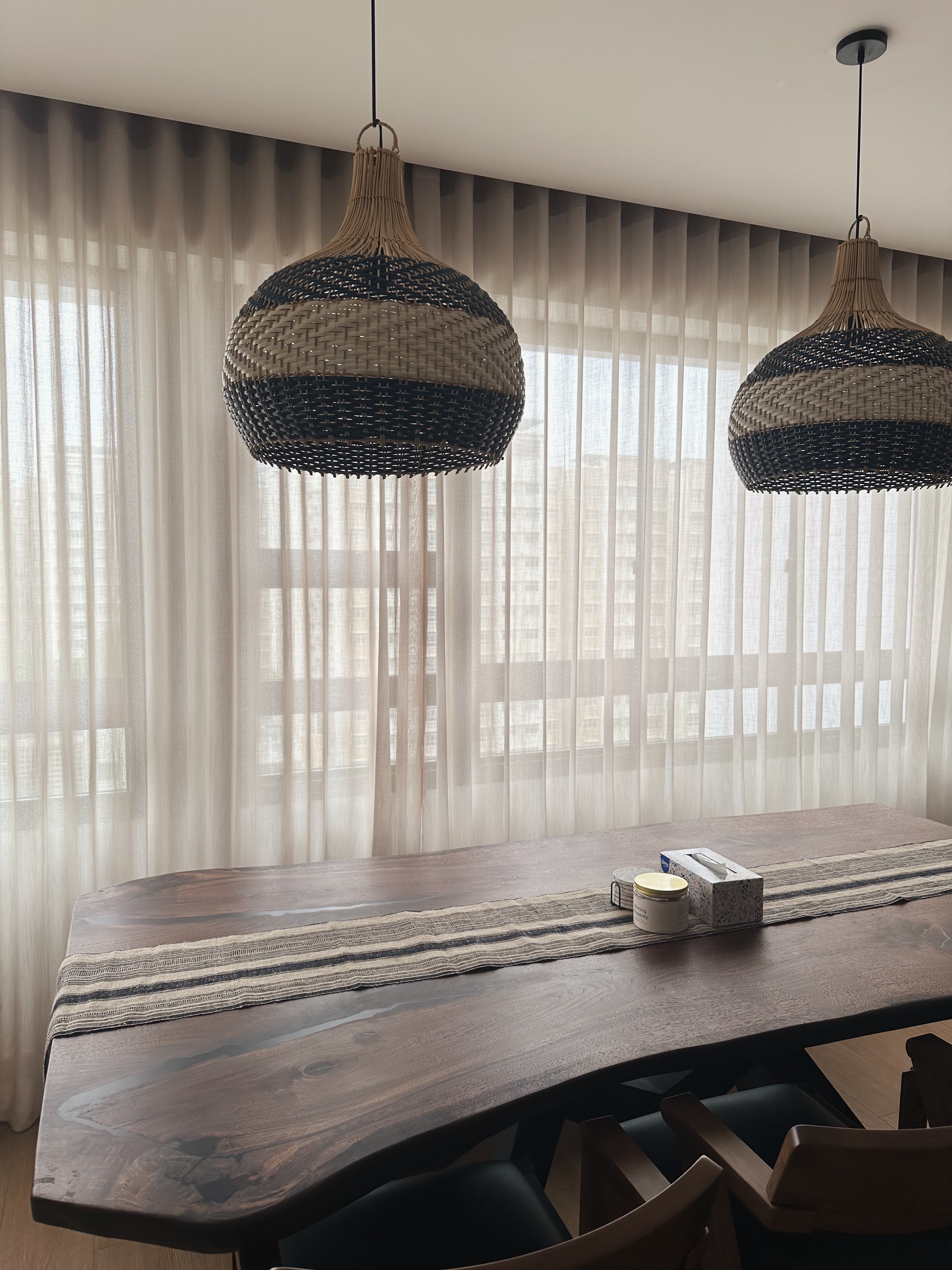 Dining space 🍷✨ - Wooden dining table, natural light streaming through sheer curtains, rustic woven pendant lights