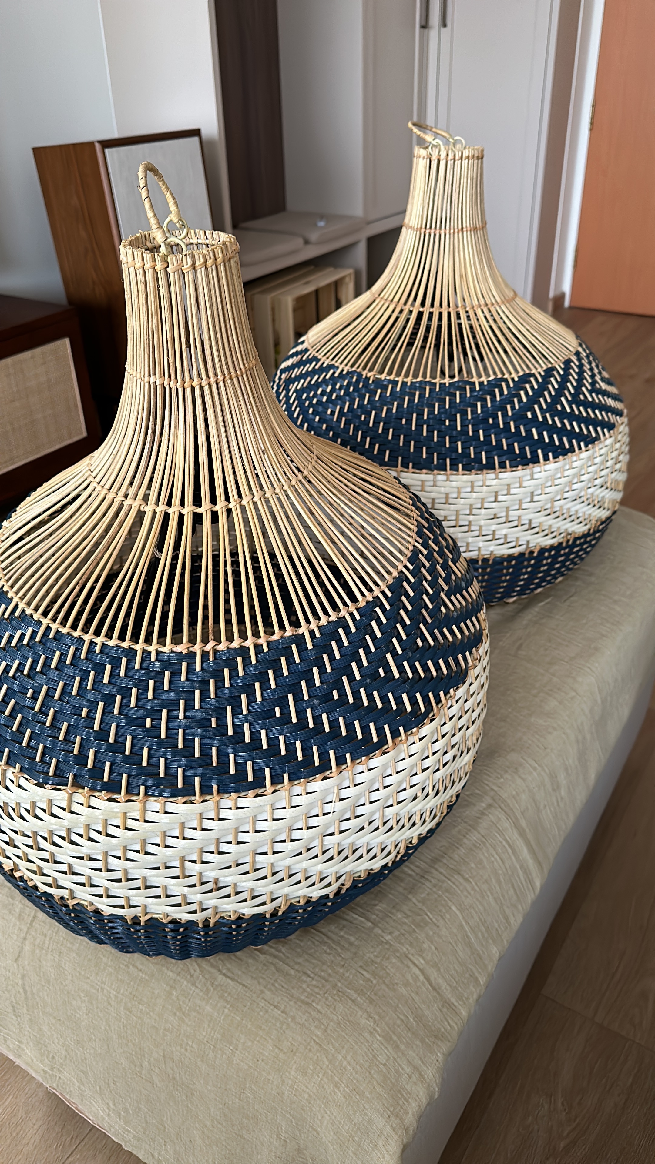 Dining space 🍷✨ - Wicker lanterns with blue and white shades, natural rattan weave, modern interior setting, beige cushion