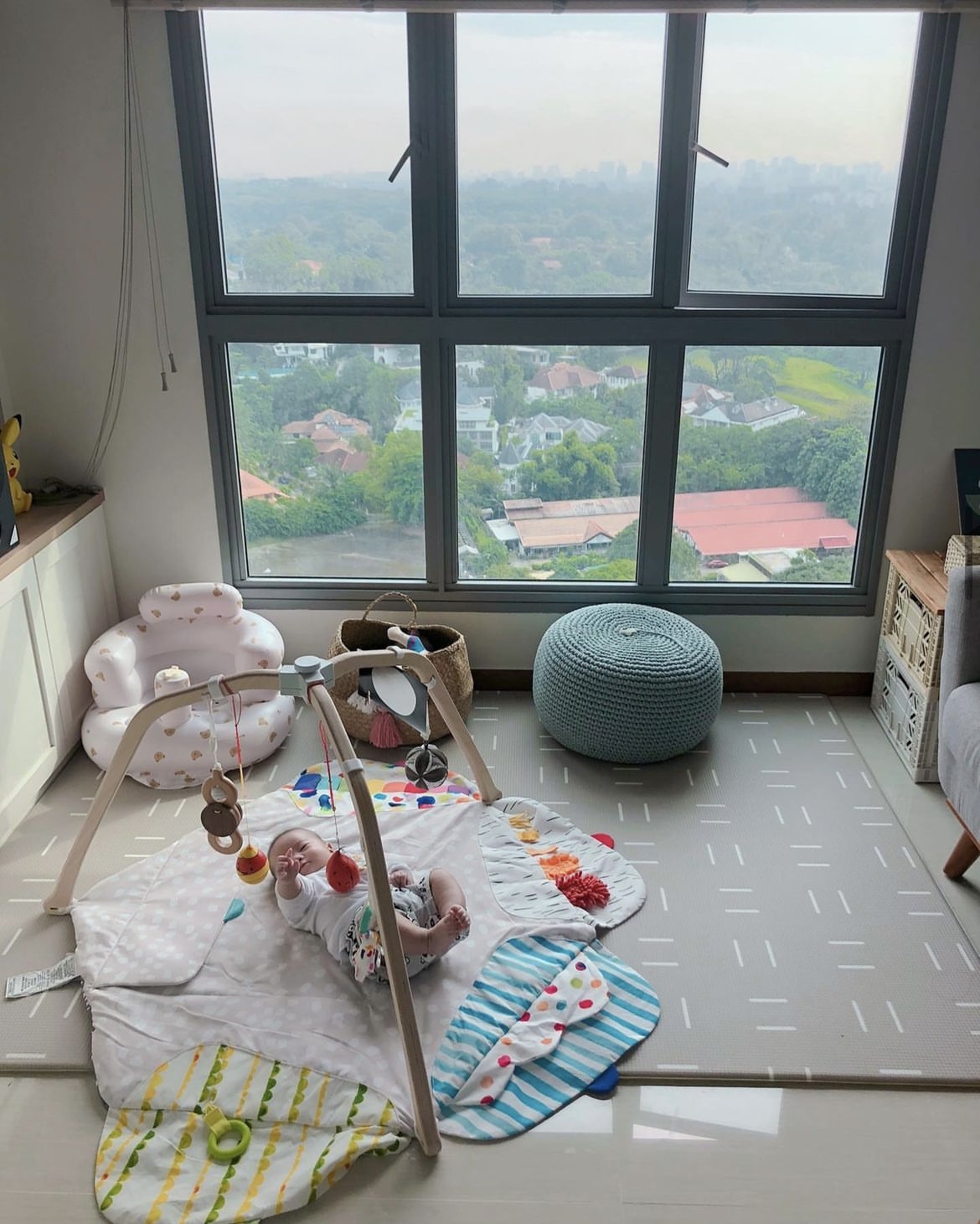 Urban Oasis: we don’t have a balcony but we have a view 🤭 - Baby lying on play mat, surrounded by colorful toys, lying on