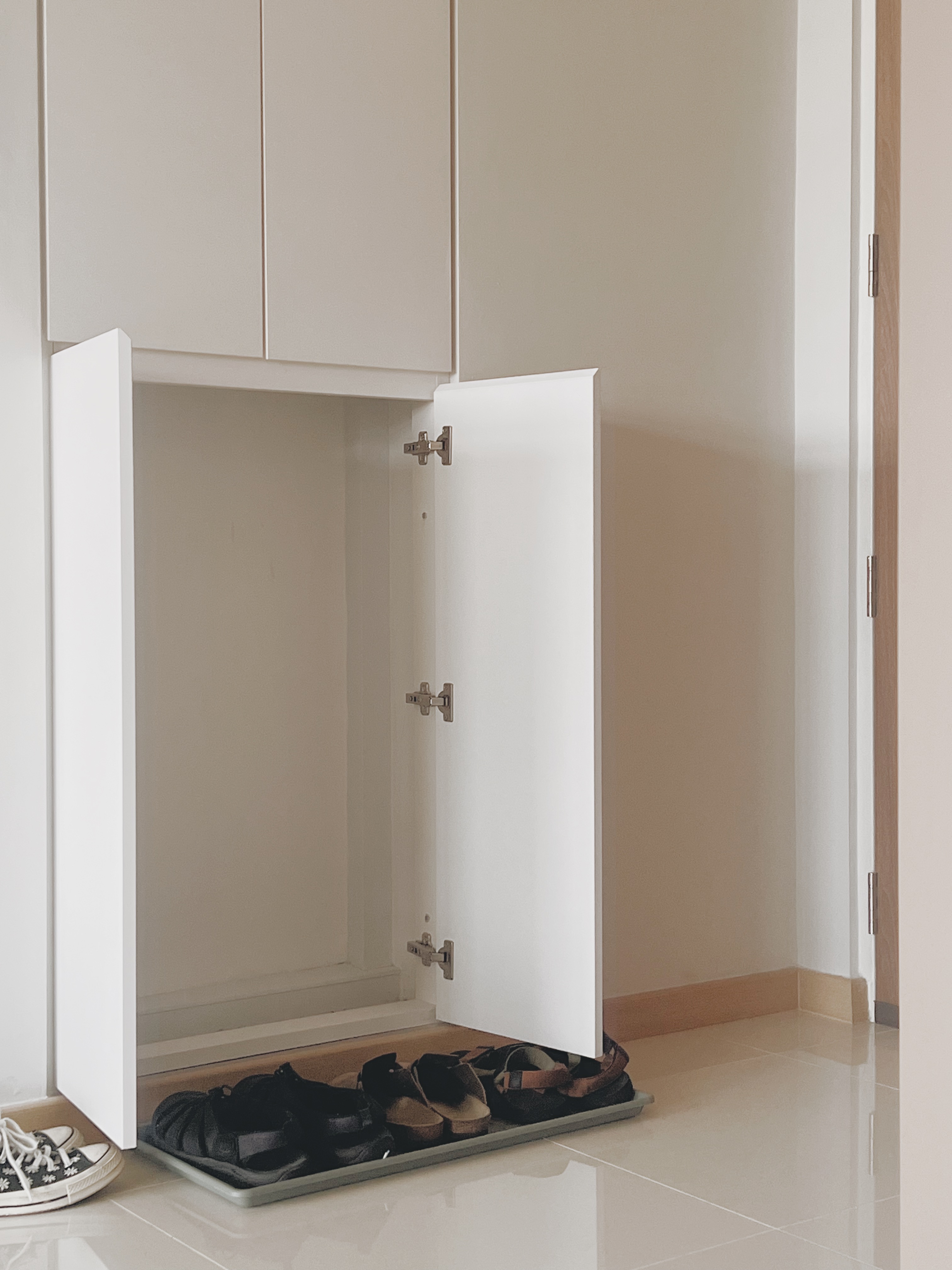 Shoes, Clutter, and $13: Our DIY Journey to a Neater Entryway - White open closet with neatly arranged shoes, minimalist