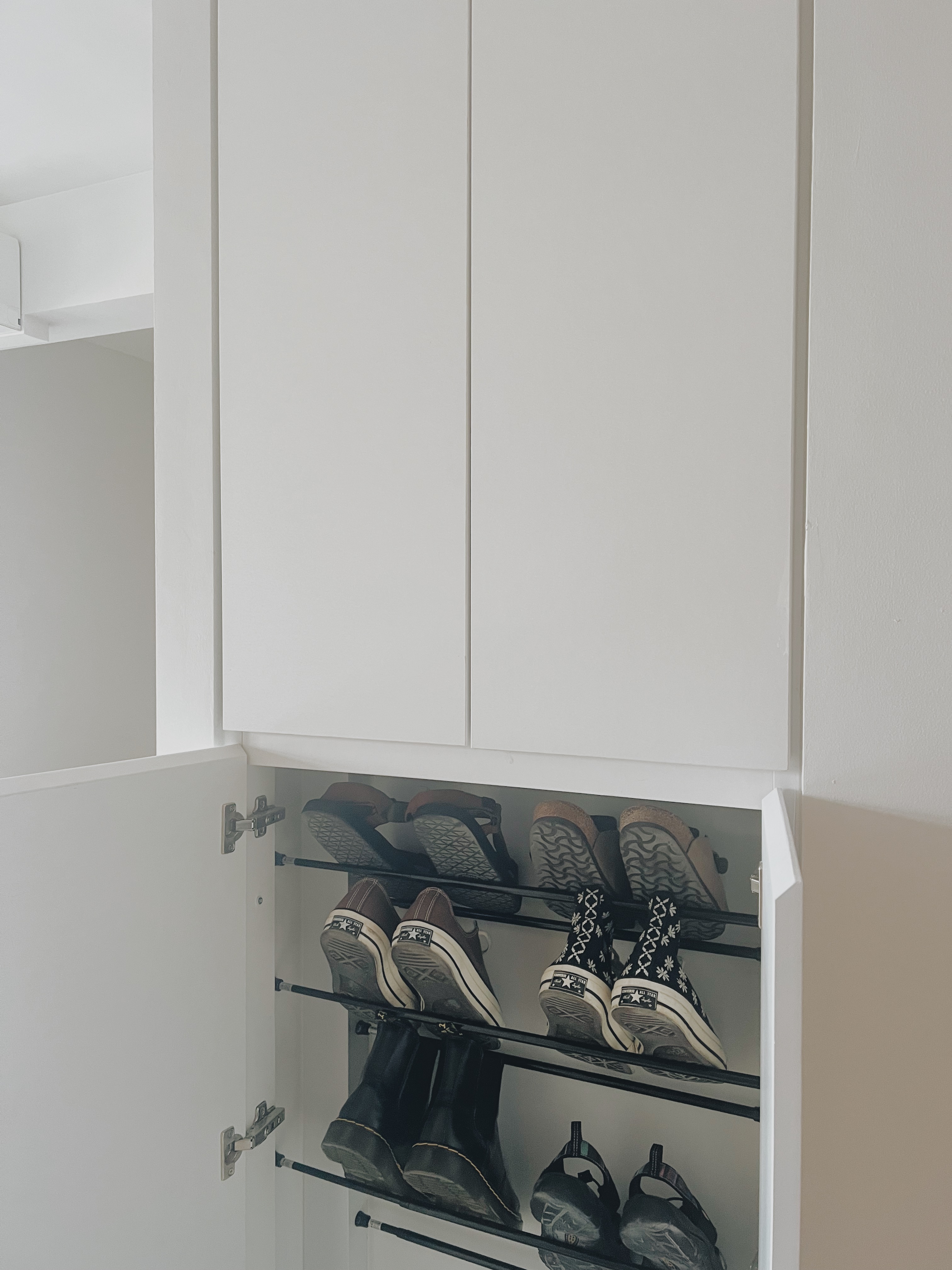 Shoes, Clutter, and $13: Our DIY Journey to a Neater Entryway - White closet with open doors, neatly organized shoes, black