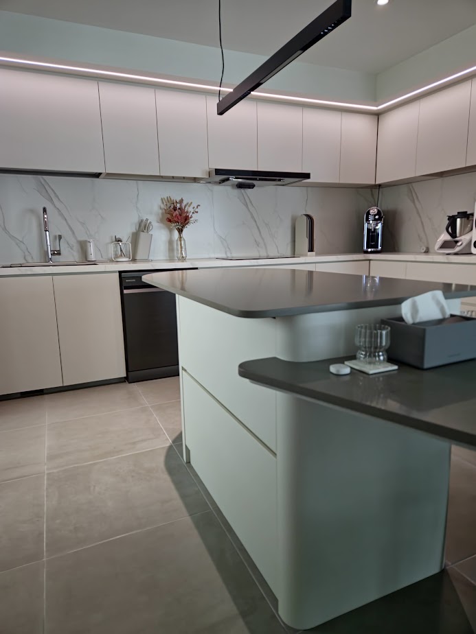A Smart and Functional Kitchen - Modern kitchen with sleek white cabinetry, marble backsplash, and under-cabinet lighting.
