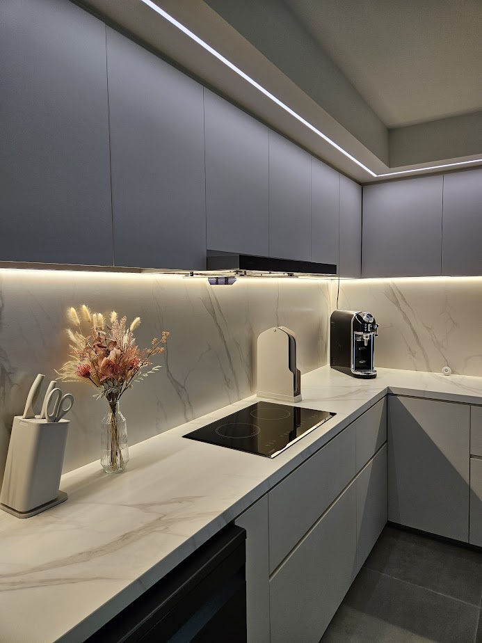 A Smart and Functional Kitchen - Grey kitchen cabinetry, marble countertops, sleek appliances, modern design, minimalist