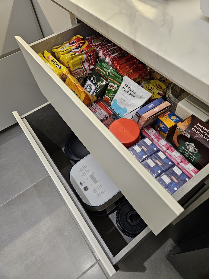 A Smart and Functional Kitchen - Mini fridge drawer, neatly organized snacks, assorted chips, chips and candy, coffee beans