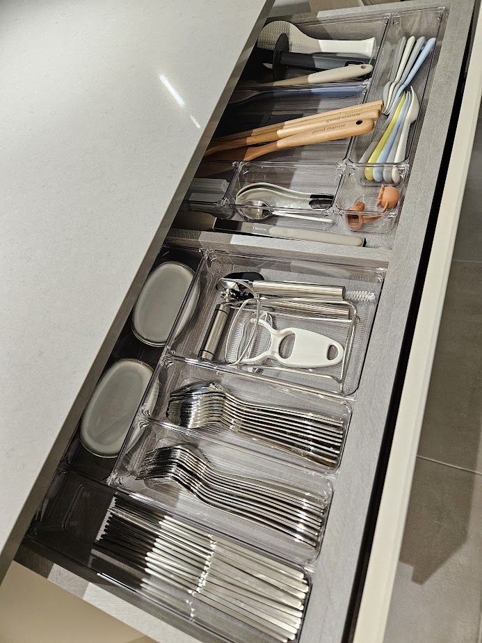 A Smart and Functional Kitchen - Clear plastic drawers, neatly organized utensils, stainless steel spoons, forks, knives, and