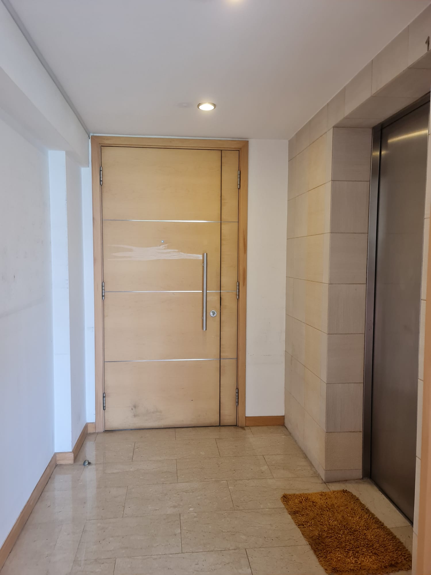 Redesigning an old condo unit to be inviting and warm - Wooden door, modern design, light beige color, metallic handle
