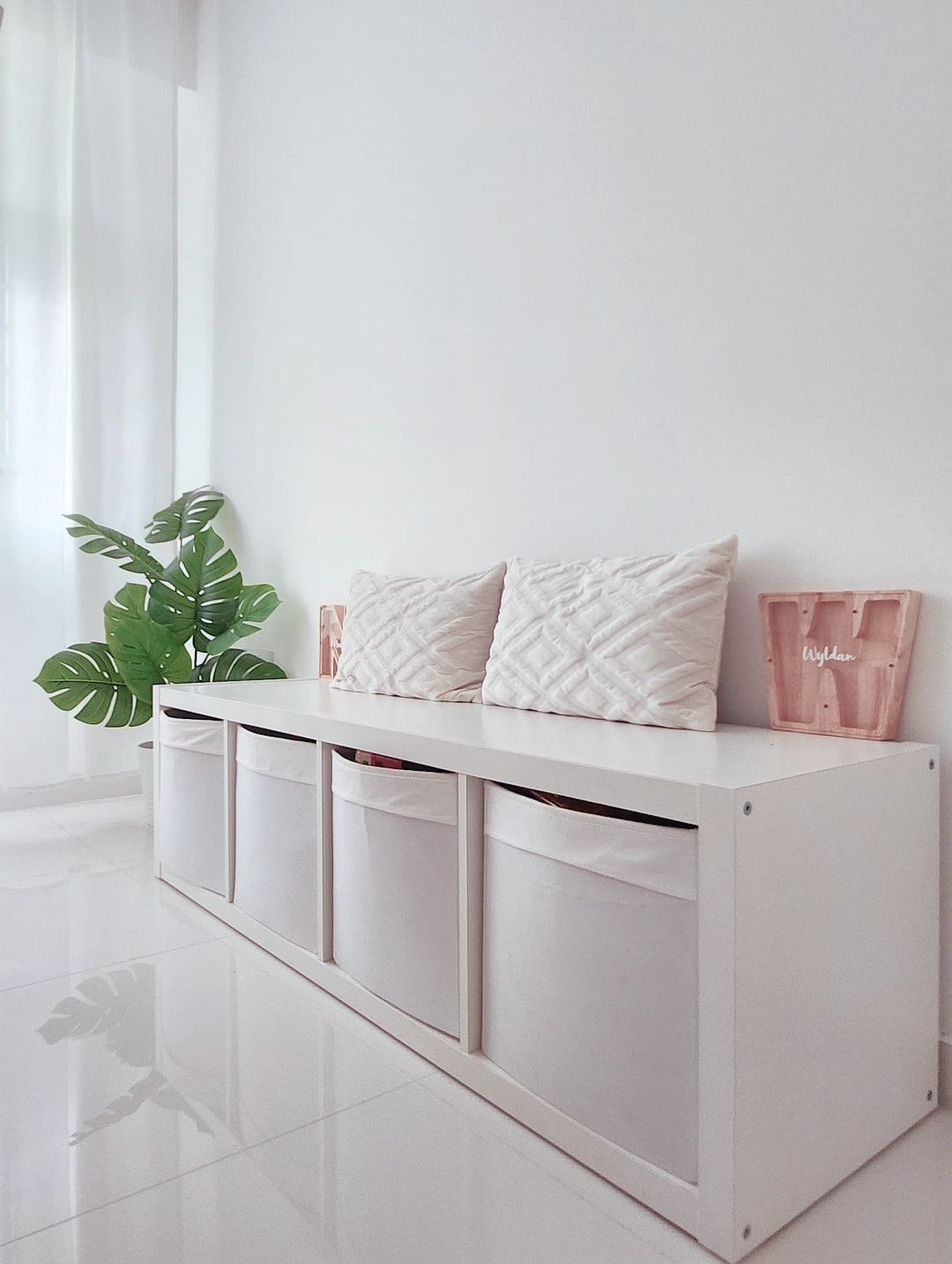 Move-a-round plants - White minimalist storage unit, modern decor, clean lines, floating shelves, decorative pillows, soft