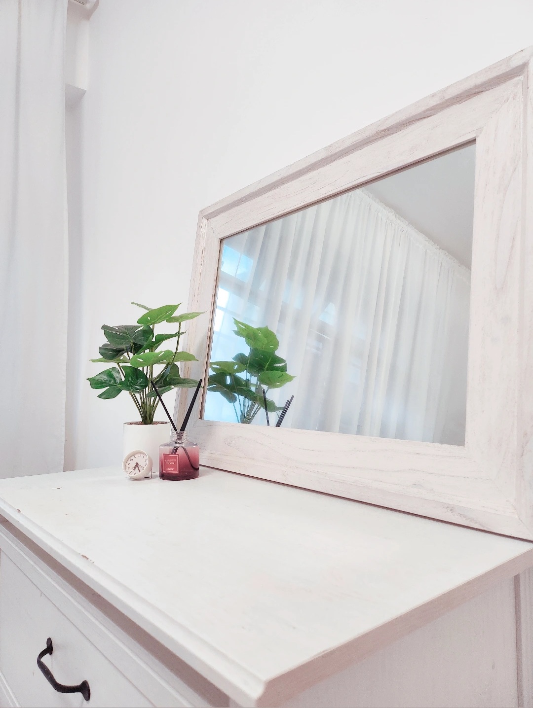 Move-a-round plants - White vanity, minimalist decor, potted plant, light wood mirror, white wall, natural light, indoor