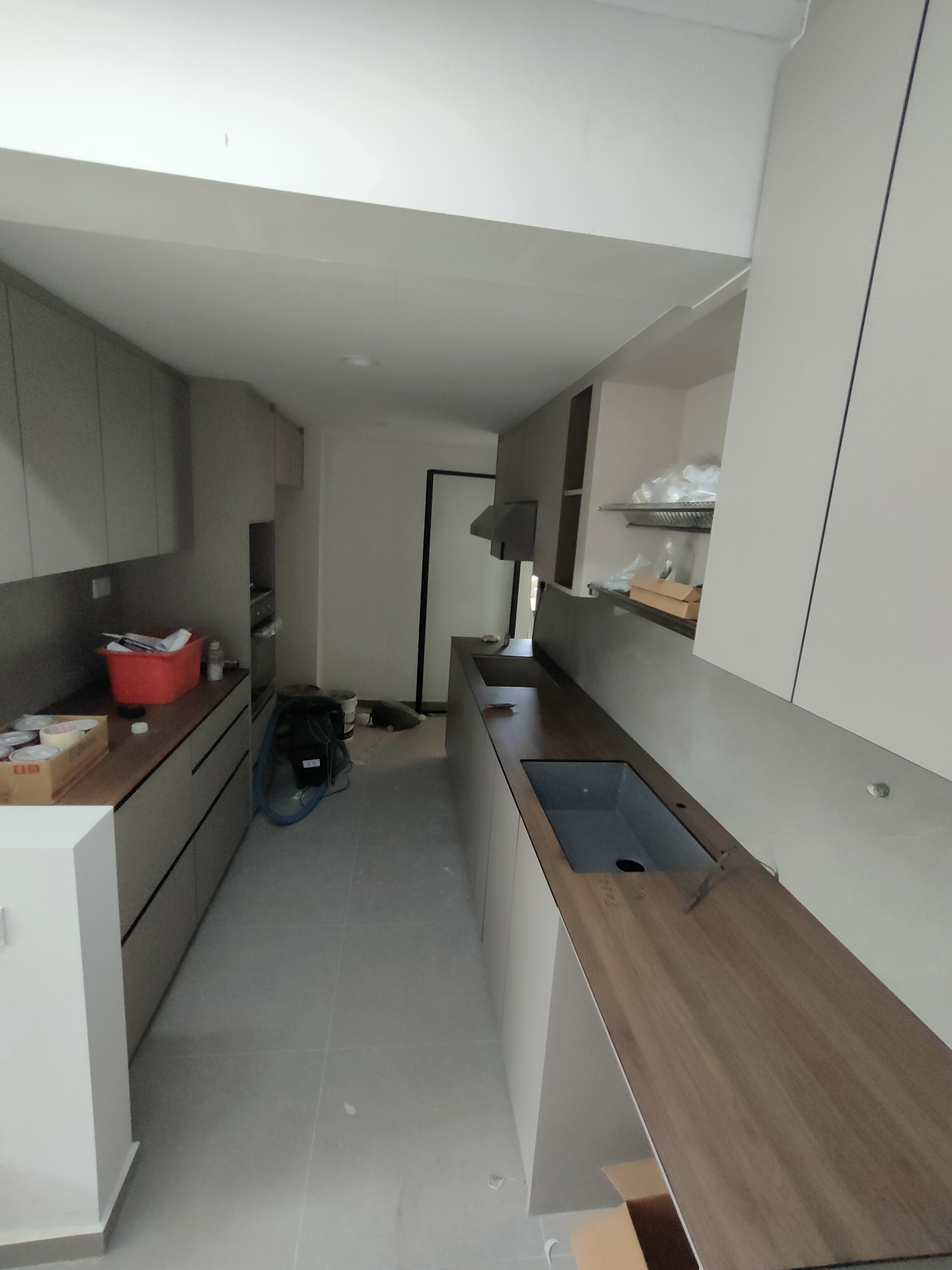 the heart of our home--Our kitchen! - Modern kitchen with sleek cabinetry, gray countertops, and wooden backsplash. Kitchen