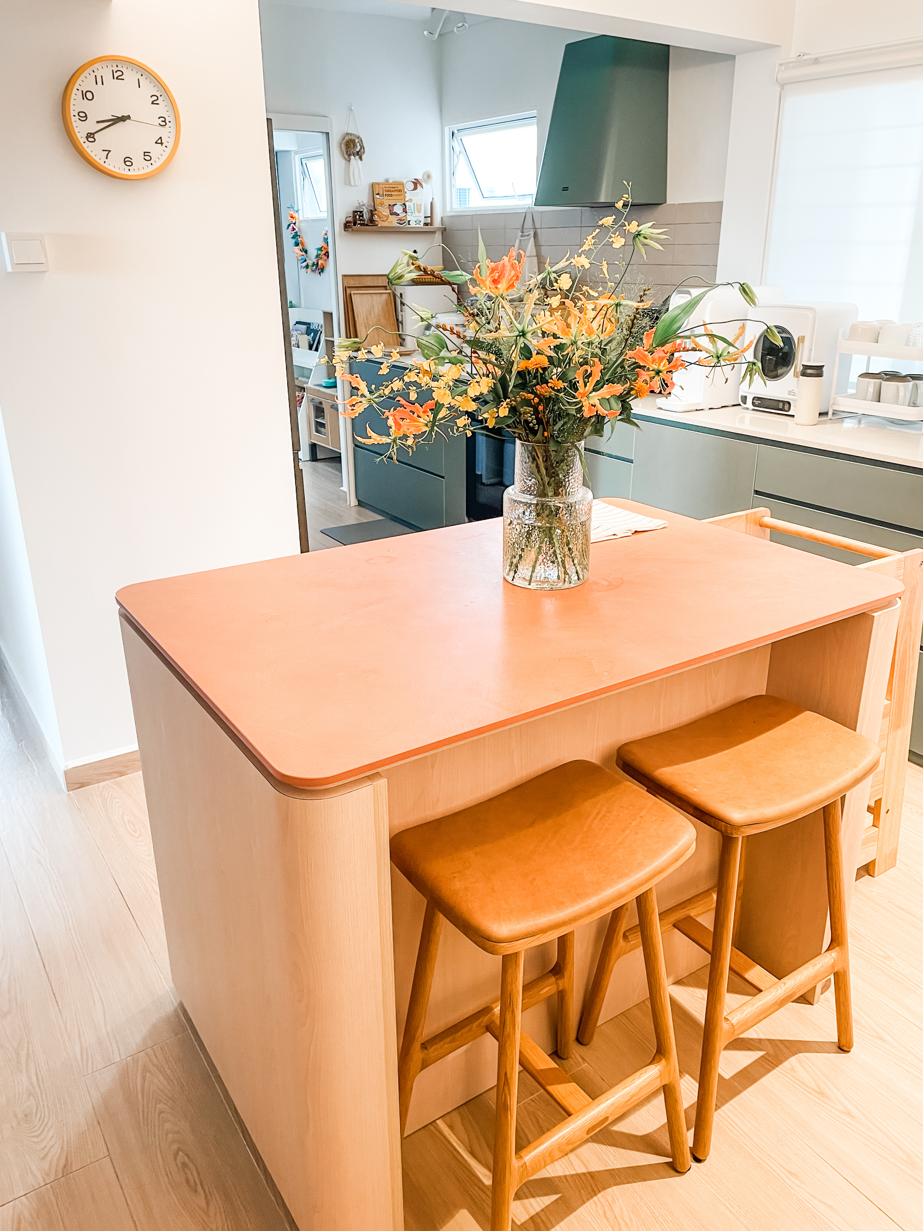 An Open-Plan Kitchen With A Secret "Mama Shop"  - Modern kitchen interior, orange countertop, wooden stools, minimalist