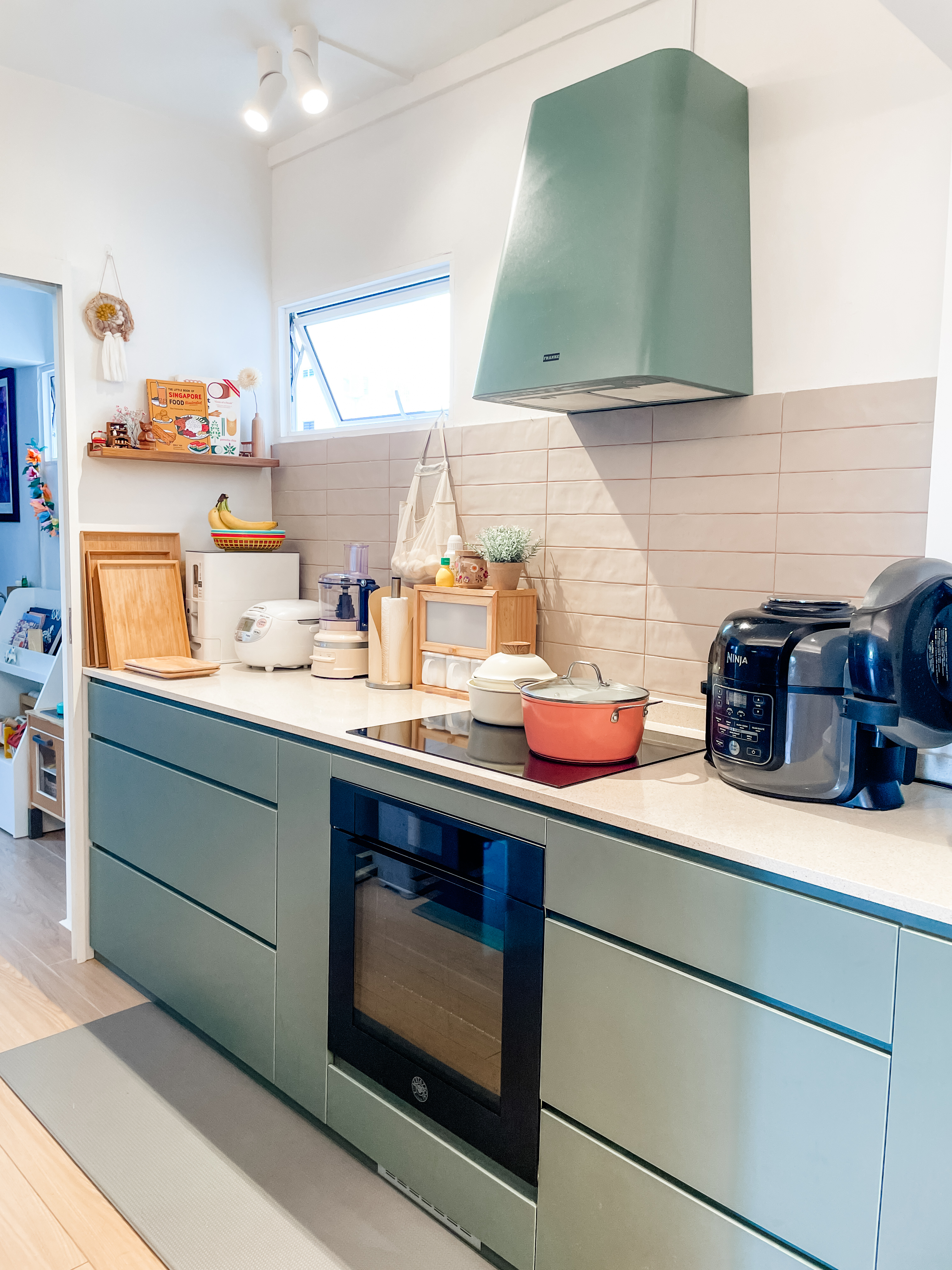 An Open-Plan Kitchen With A Secret "Mama Shop"  - Modern kitchen with sleek design, green and gray color scheme, built-in