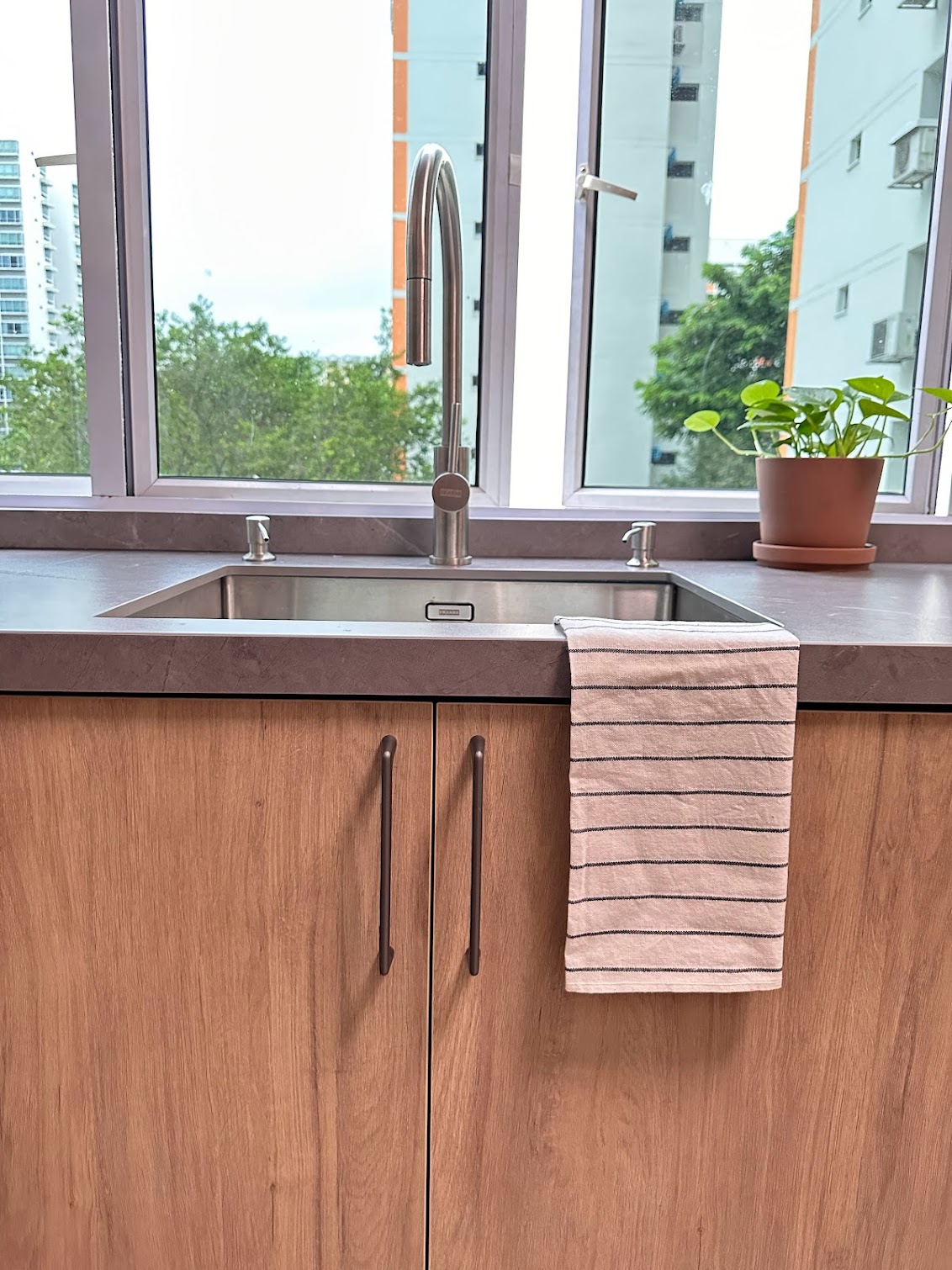 Take a Look at Our Dry and Wet Kitchens - Wooden kitchen cabinetry, stainless steel sink, modern faucet, beige striped towel
