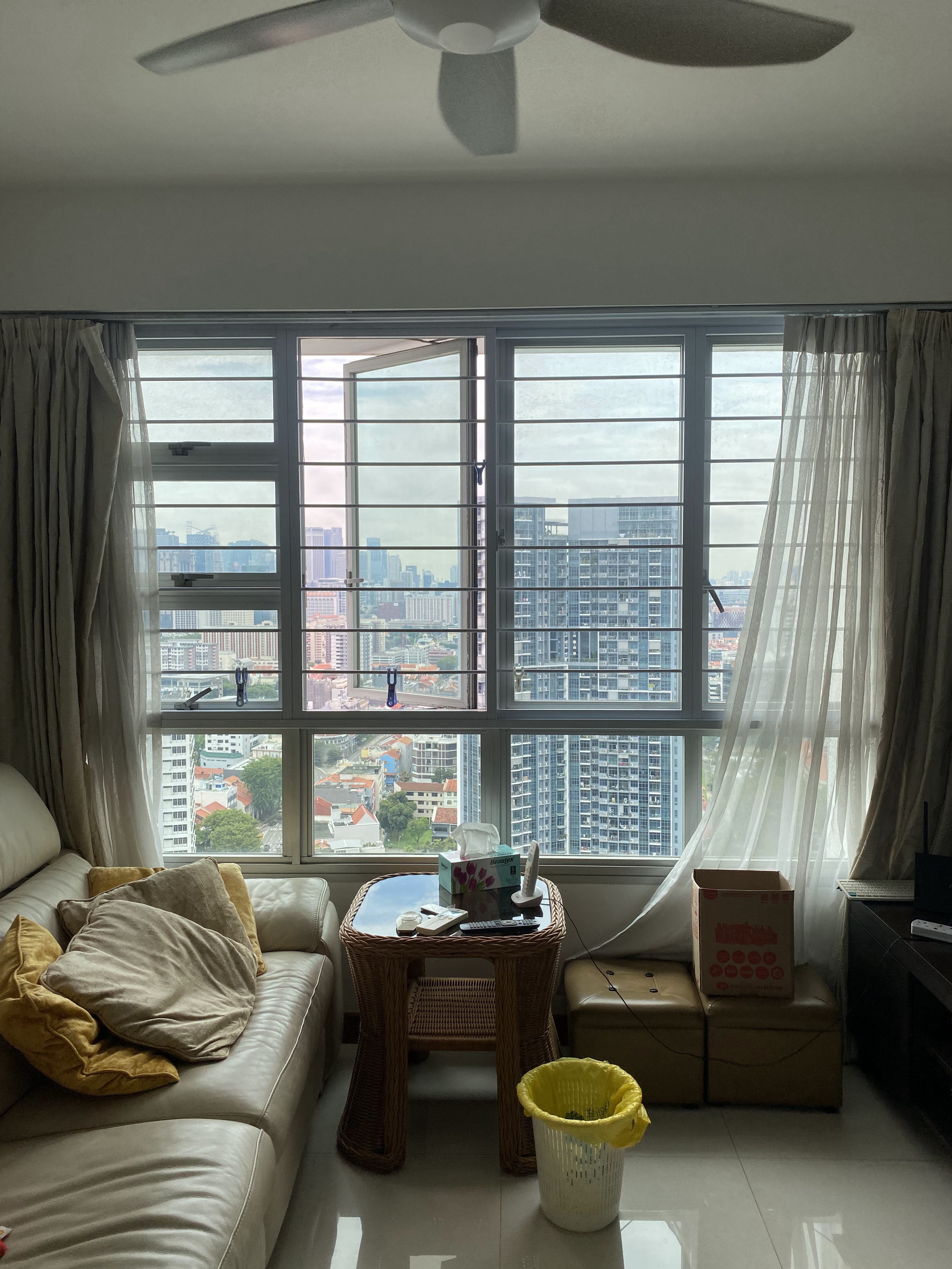 Love & Light: What Brings You Joy? - Large windows, cityscape, beige curtains, beige sofa, yellow cushions, wicker table