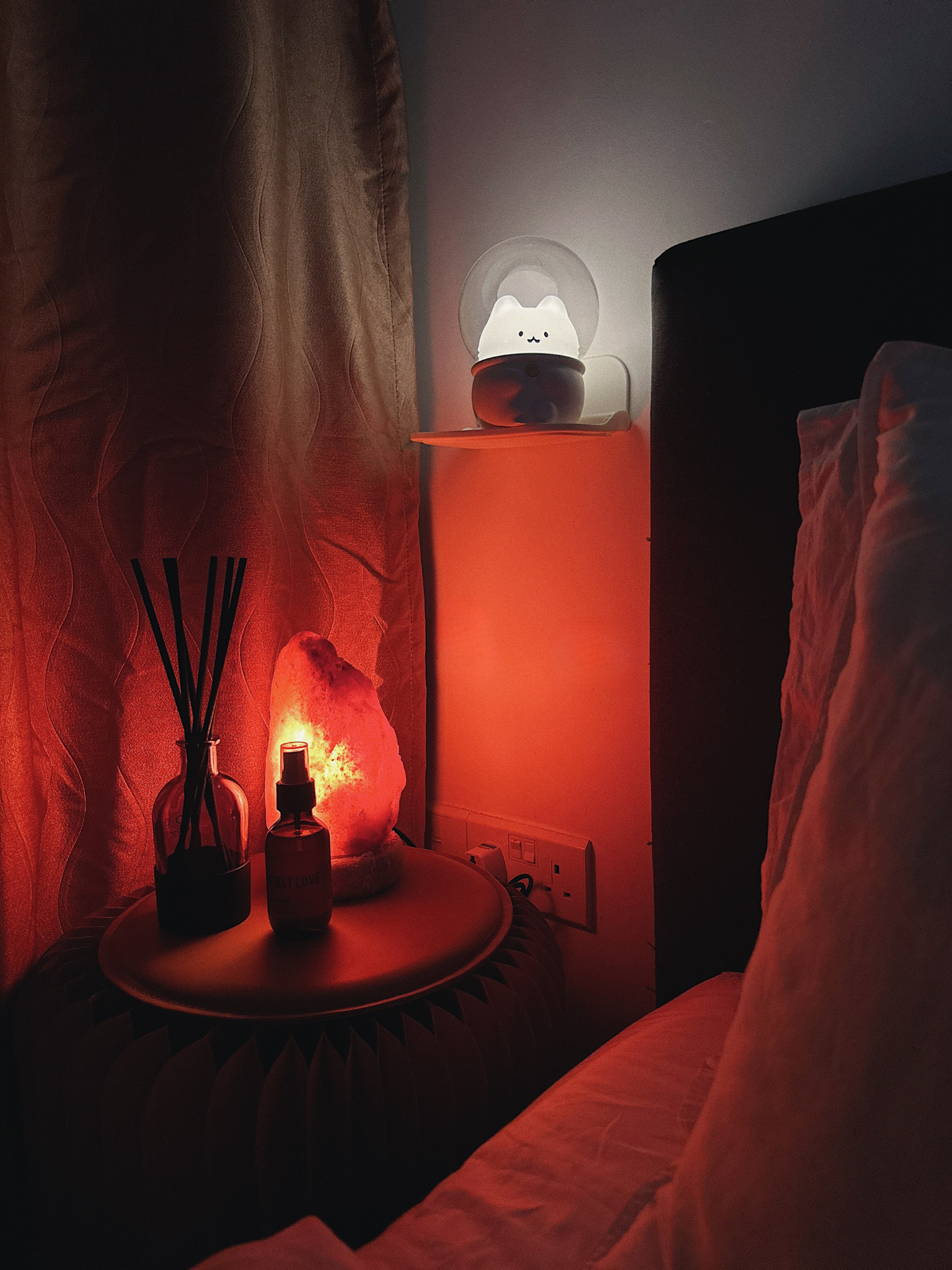 Calm & Cosy: Our Sleep Hacks for a Restful Night - dimly lit room, cozy ambiance, soft lighting, red glow, nightstand