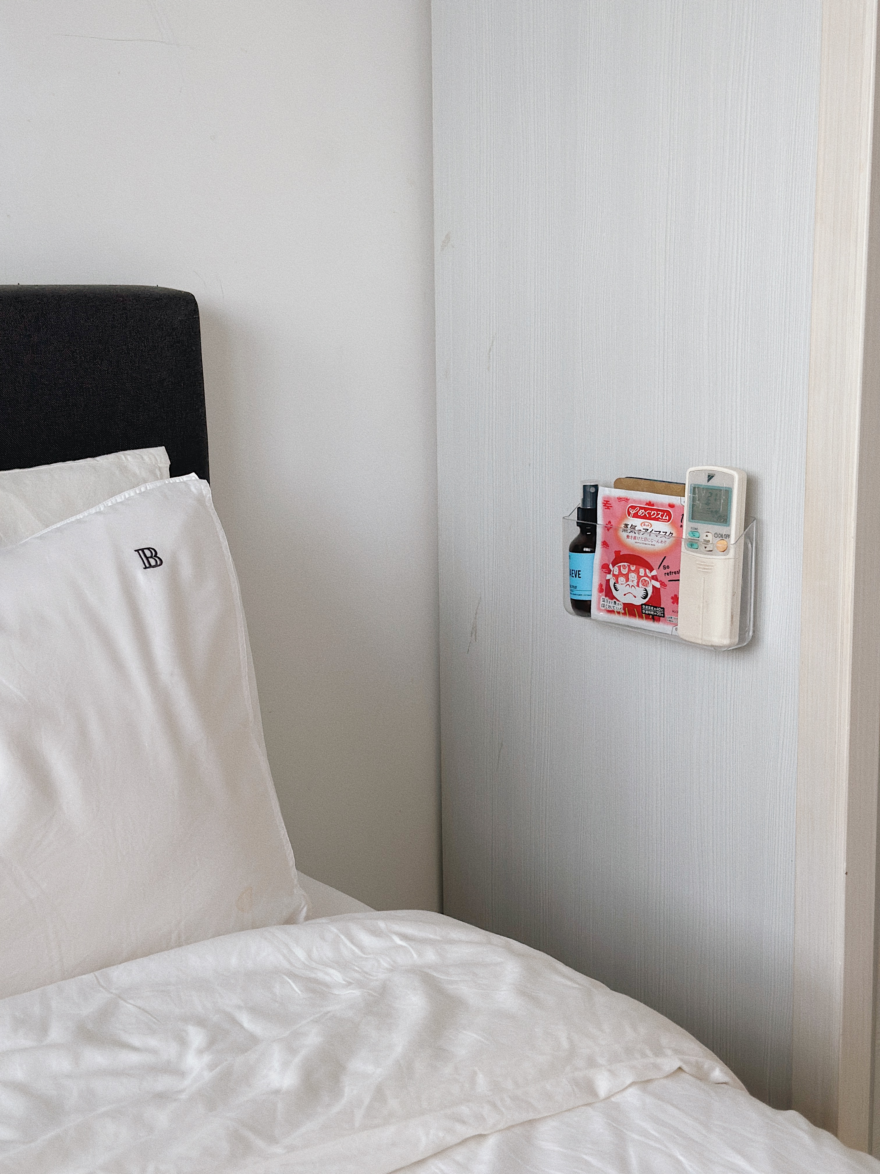 Calm & Cosy: Our Sleep Hacks for a Restful Night - White bed with neatly made bedspread, black headboard, white pillows