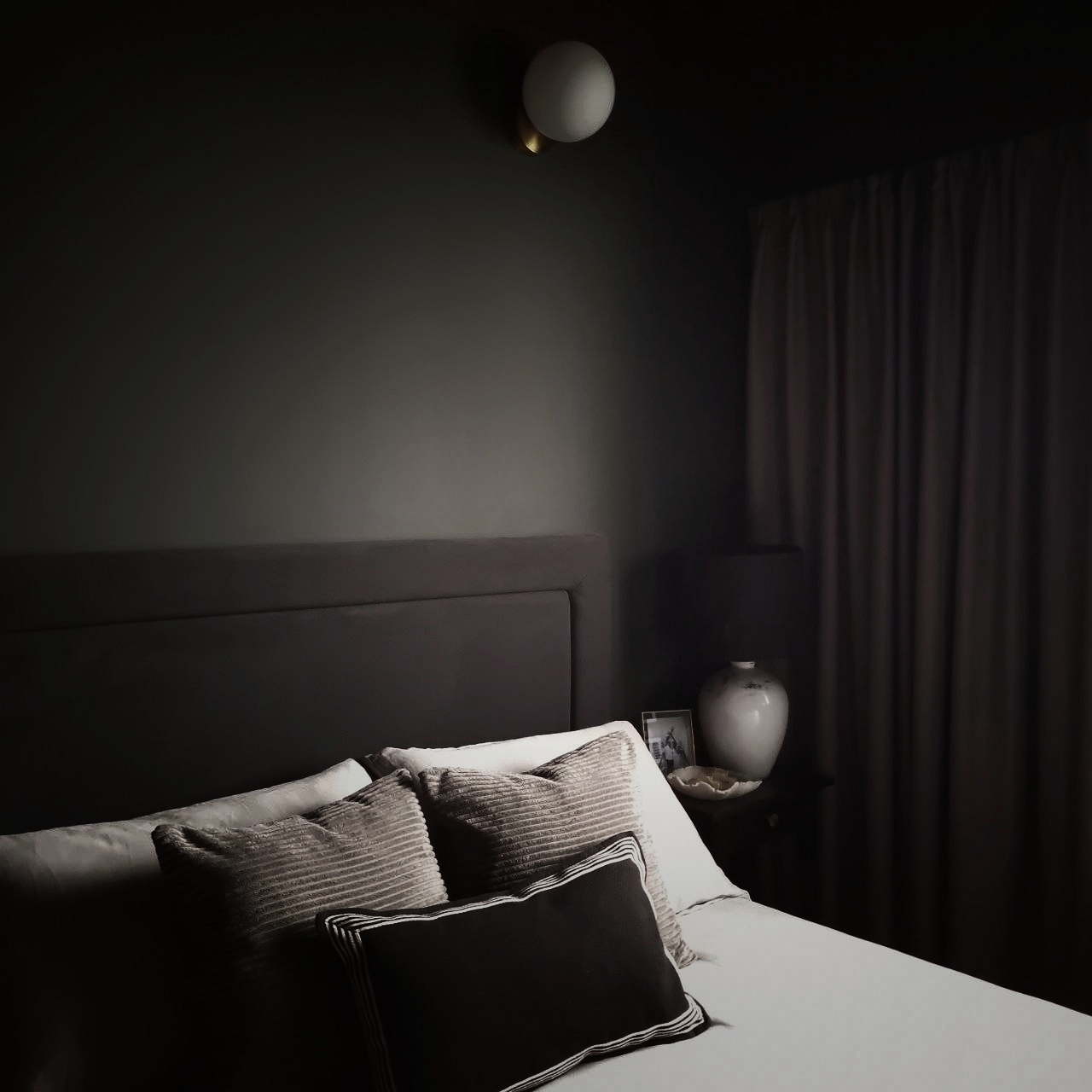 A Glimpse of Our Dark Grey Bedroom - dimly lit bedroom, cozy atmosphere, soft lighting, modern decor, textured pillows, dark