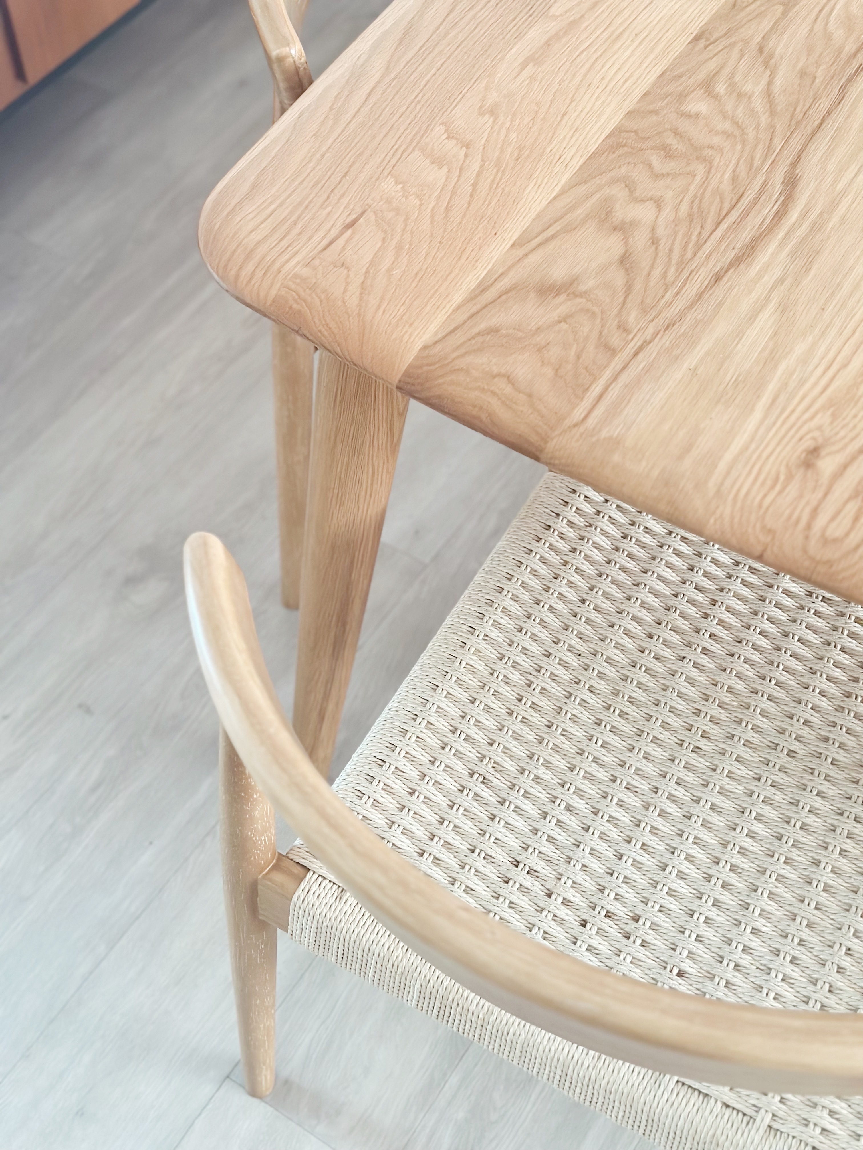 Warm & Cosy Minimal Dining Space - Light wood table with natural grain texture, light wooden legs, woven chair seat, light