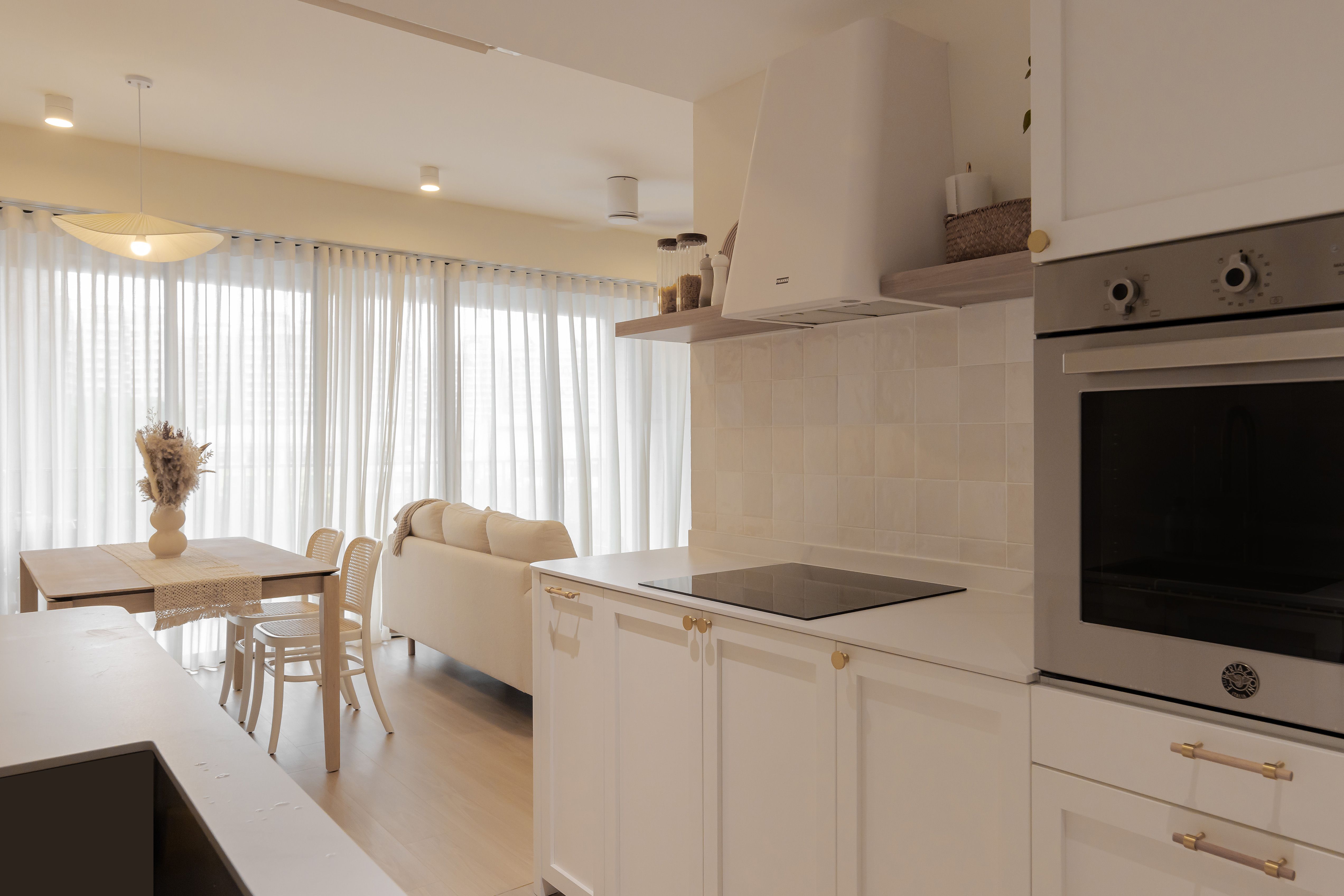Our unconventional “ALL WHITE” kitchen with no top cabinets - Modern kitchen with white cabinetry and gold handles, stainless