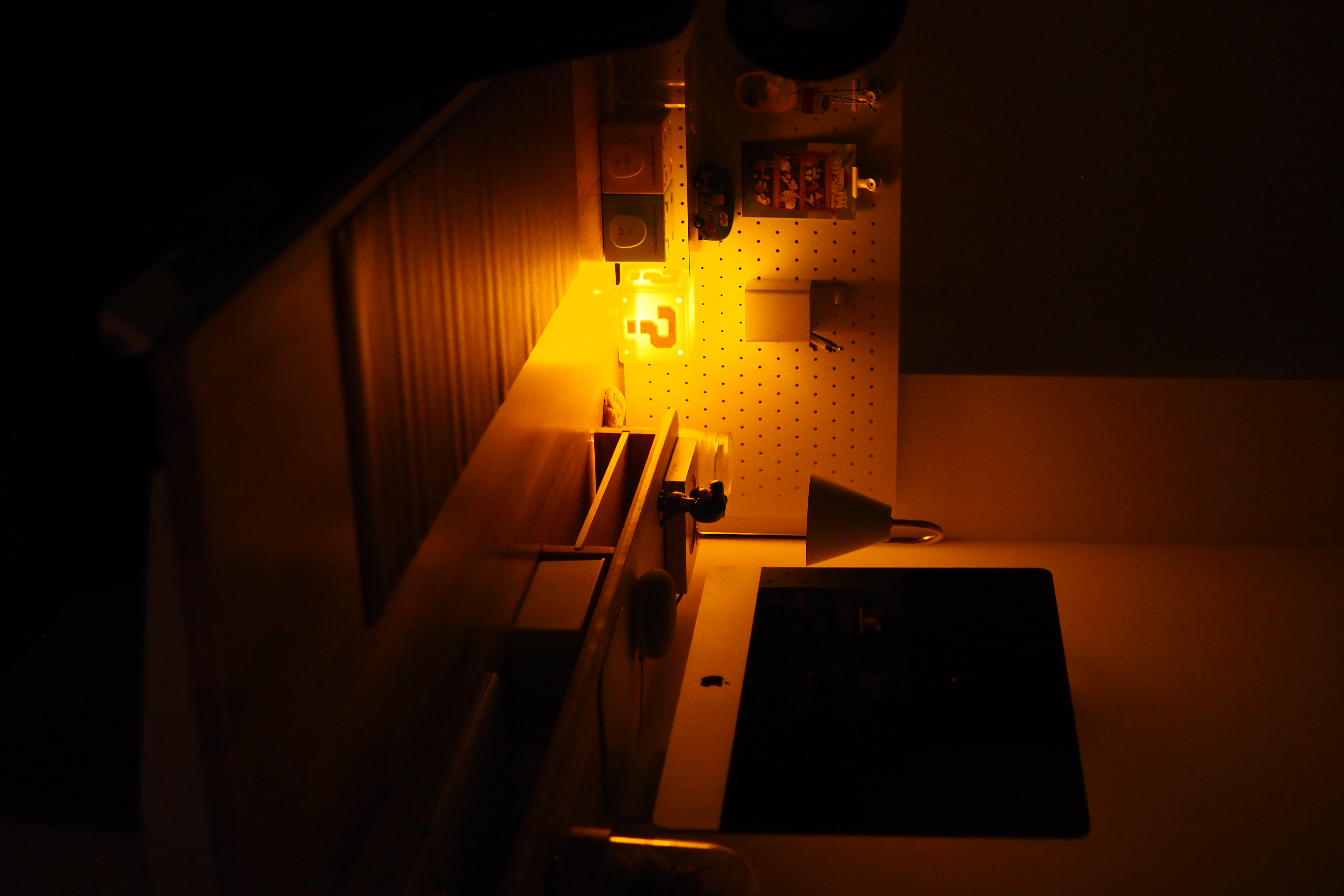 Let there be light, from morning to night - dimly lit workspace, cozy ambiance, warm lighting, cluttered desk, illuminated