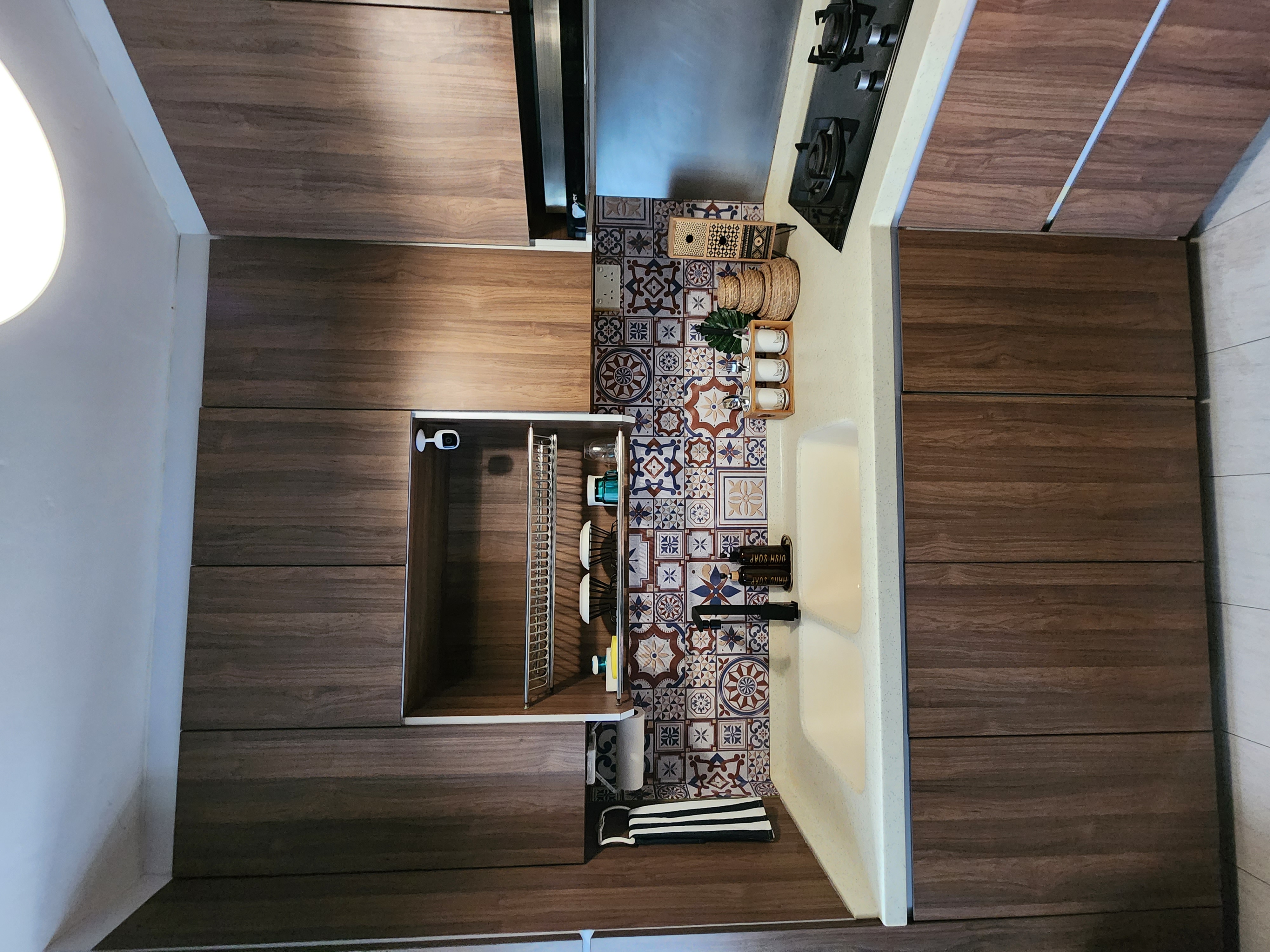 The Earthy Kitchen - Wooden cabinetry, tiled backsplash, modern design, open storage compartment, stainless steel sink, black